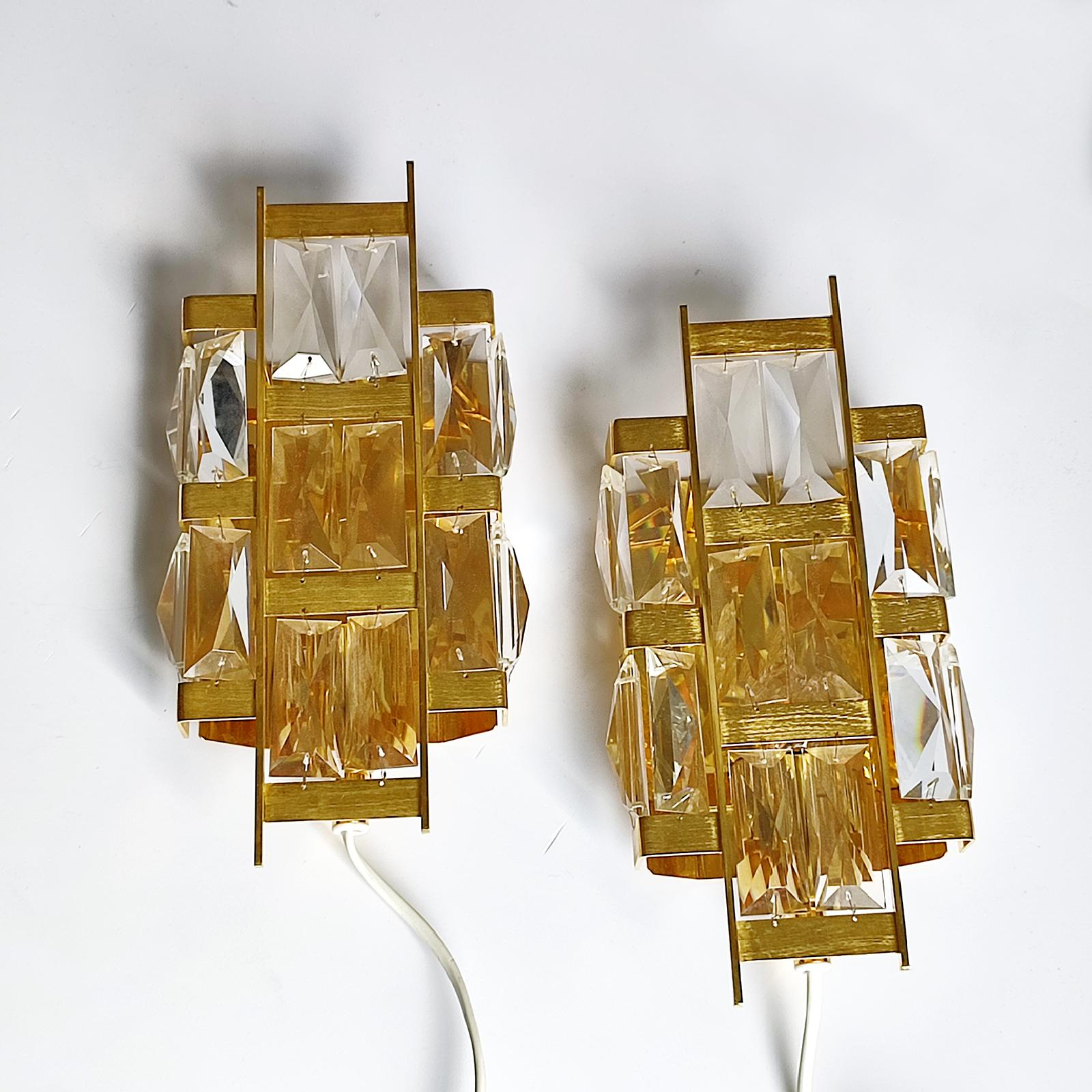 Exquisite and rare wall lamps from the 1960s.
Made of gold-plated brass and rectangular faceted crystal petals to give a very pleasant lighting effect.
The brass body is detailed worked, showing a deep brushed structure.
Excitingly beautiful design