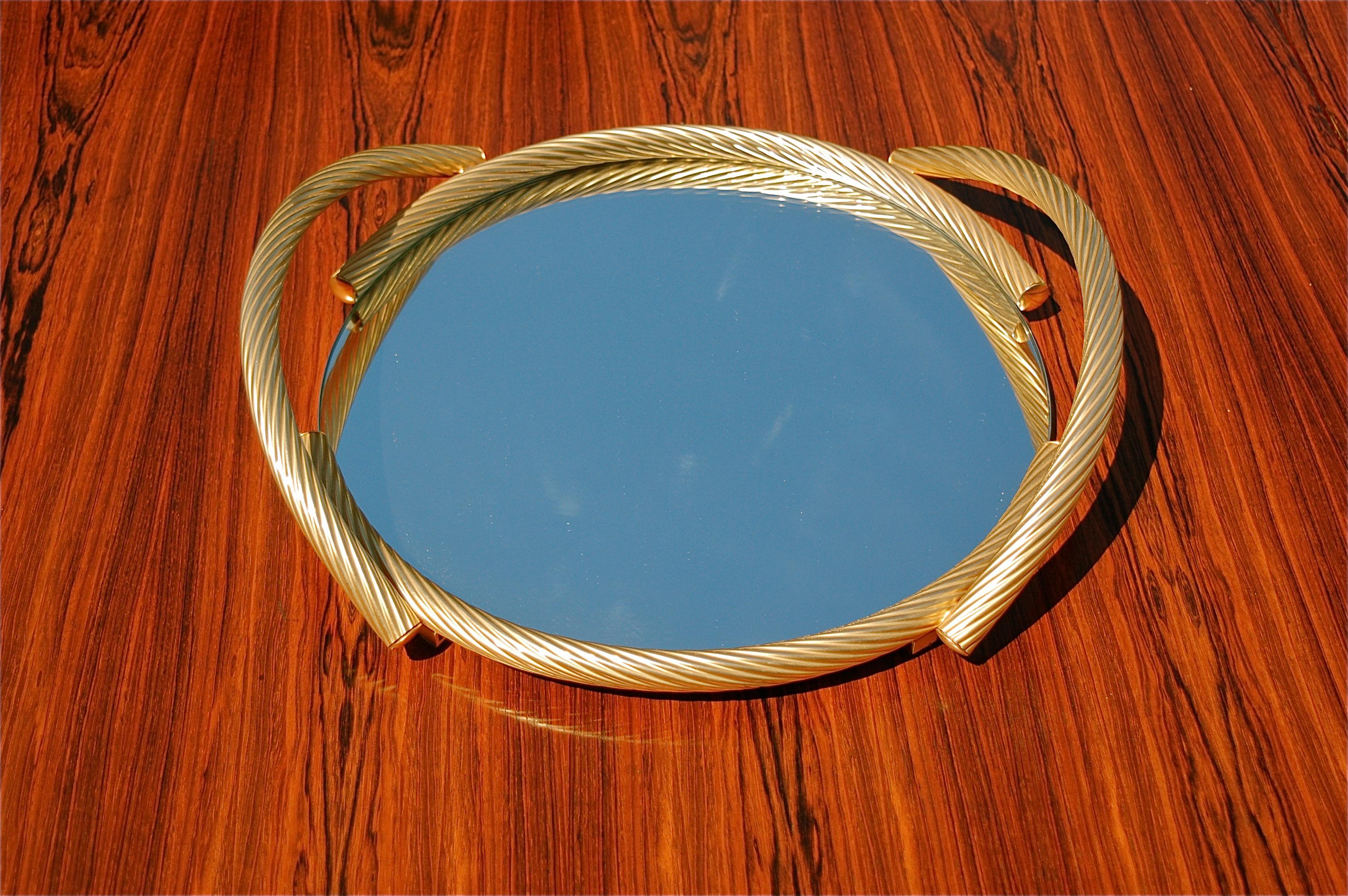 Circular mirrored serving tray in tempered glass with 6mm thickness. 24K Gold plated handles and trim are mounted along the edge of the tray. It has quality finishes like the rope twist effect and leather covered base.  To use as a drinks tray or