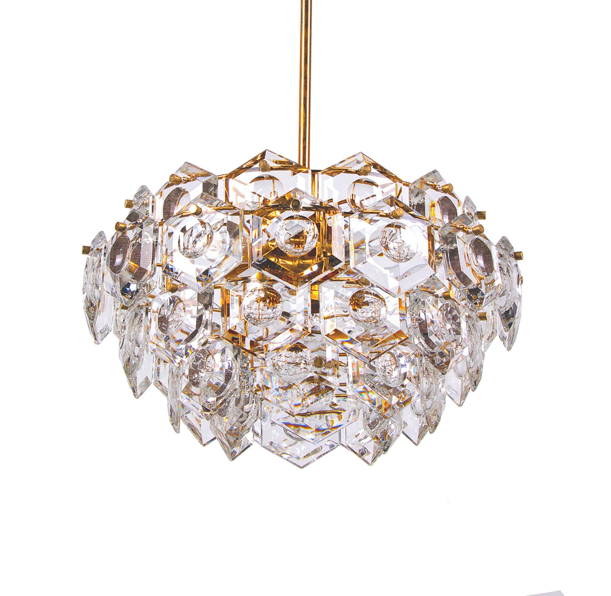 Elegant chandelier with sculptural faceted crystals on a gold-plated brass frame. Chandelier illuminates beautifully and offers a lot of light. Gem from the time. With this light you make a clear statement in your interior design. A real eye-catcher