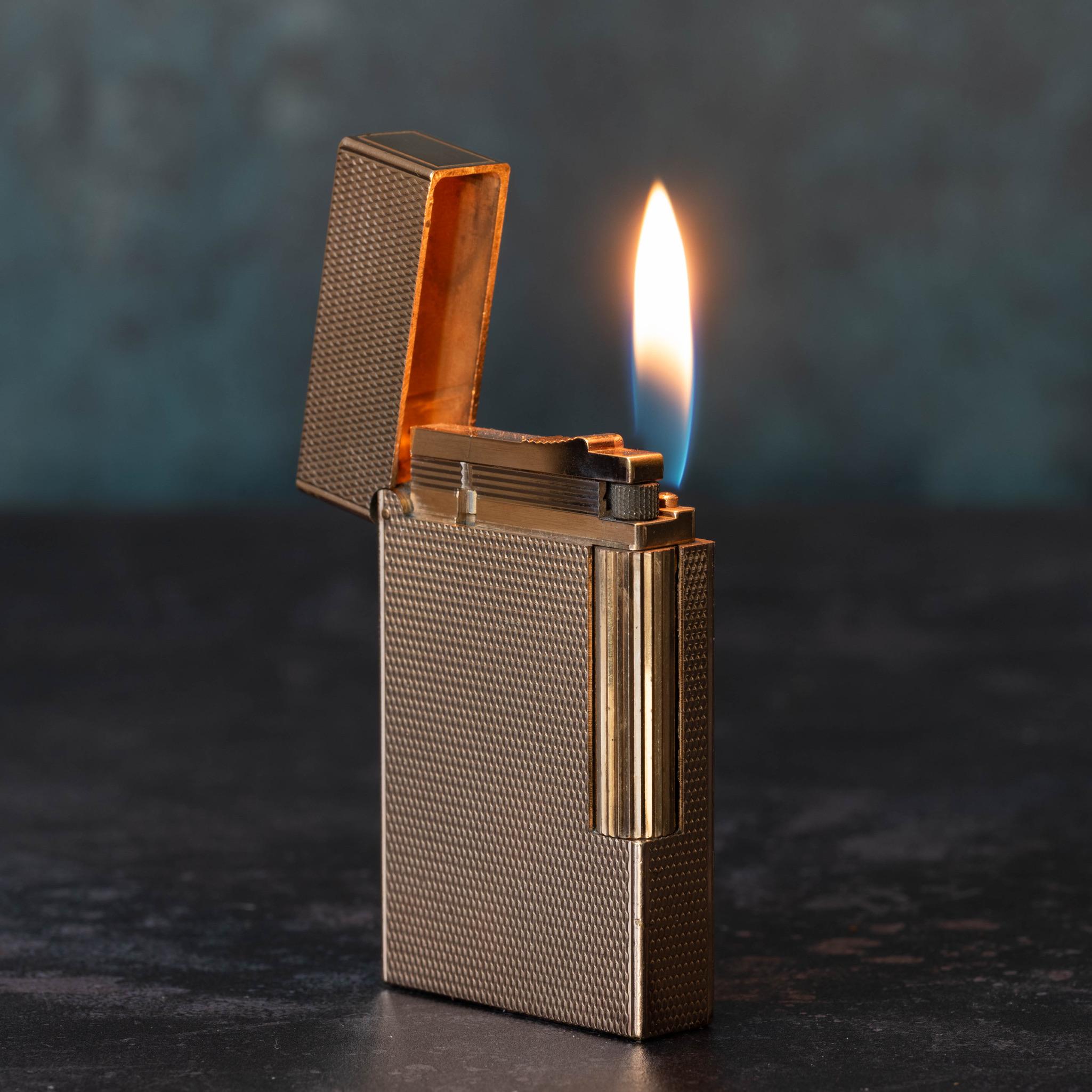 Stylish Dupont Ligne 2 gas lighter in rose gold plate with engine turned design, circa 1980.

Each Dupont has a serial number unique to that particular lighter. This example is marked on the base, ’S.T Dupont - Paris - Made in France' - with serial
