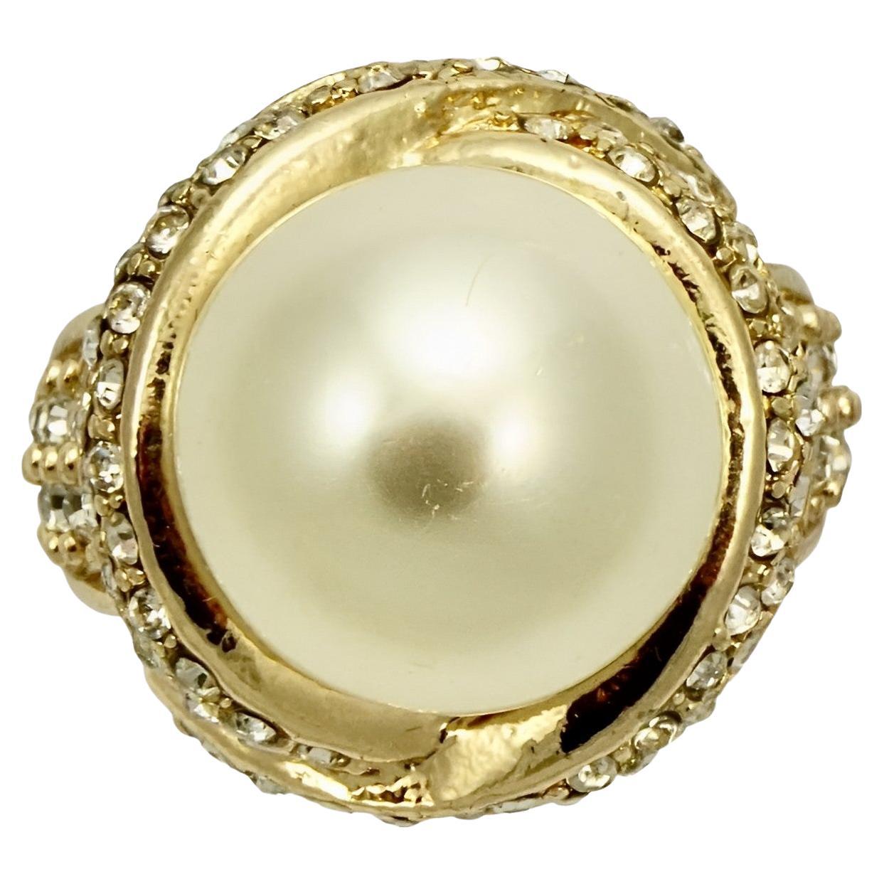 Beautiful gold plated cocktail ring, set with a large faux pearl surrounded by clear crystals. Ring size UK P 1/2, US 7 3/4. Inside diameter 1.9 cm / .74 inch. The faux pearl has some scratching.

This glamorous cocktail ring would make a fabulous