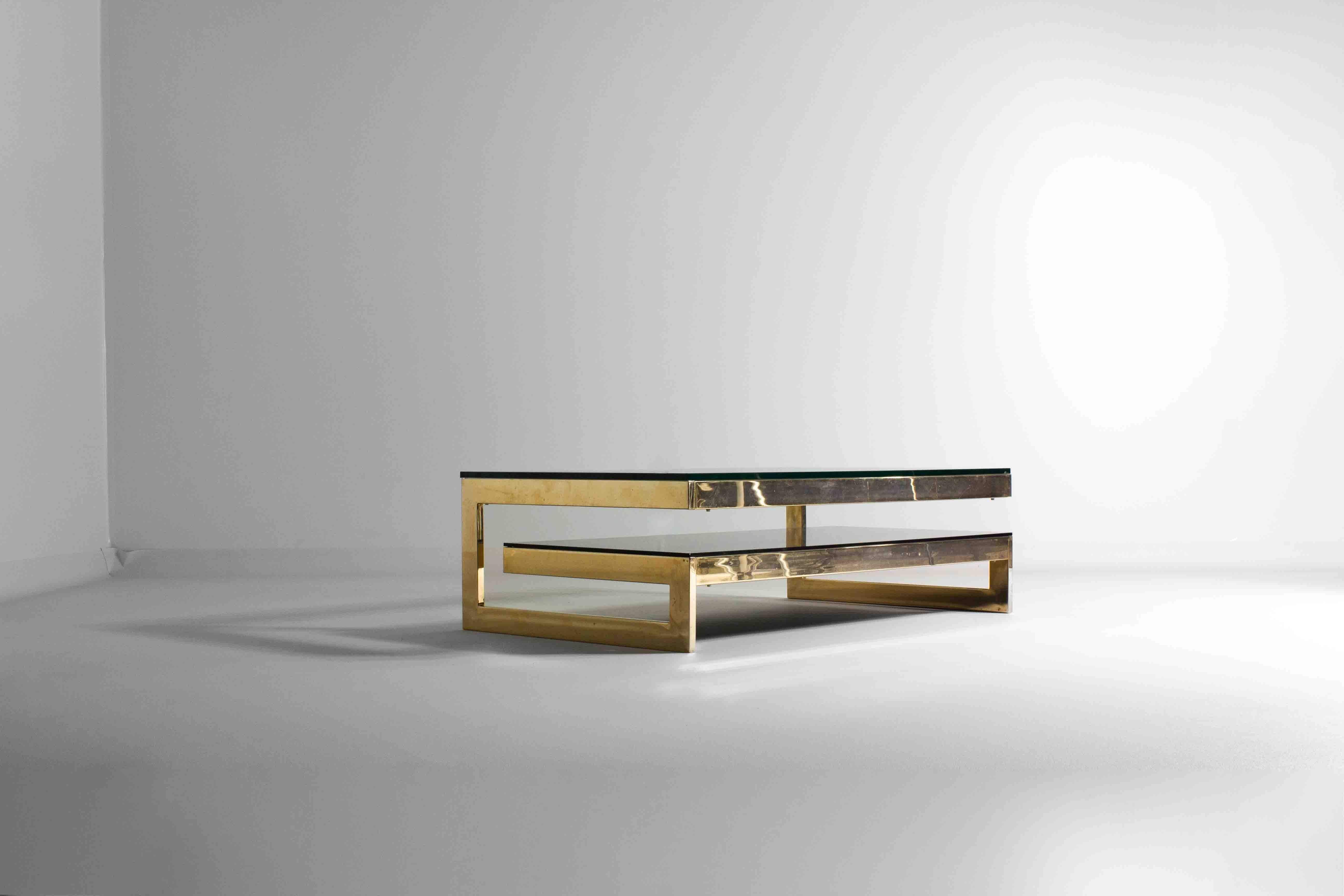 This piece is called the “G-table”, a quintessential piece of 1970s BelgoChrom. The table features a gleaming brass structure with a distinctive G-shaped silhouette that effortlessly balances modernist aesthetics with functional design. Its sleek