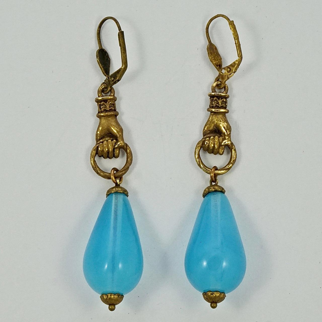 Fabulous gold plated lever back hand earrings, with beautiful blue opaline drops. Measuring length 8 cm / 3.15 inches including the lever backs. The gold plating is quite rough. The drops are in very good condition.

This is a beautiful pair of