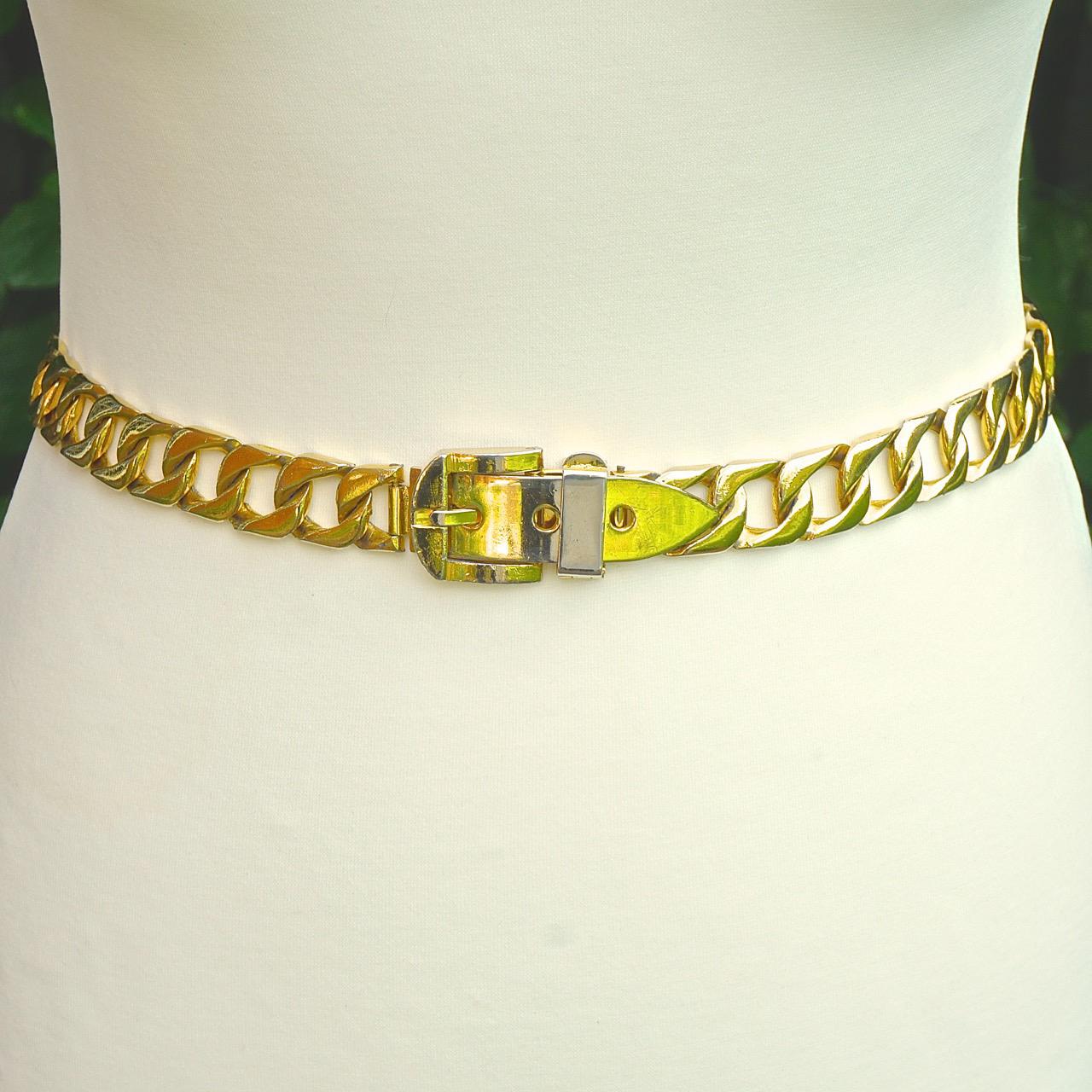 Shiny gold plated adjustable curb link chain belt, with a buckle design. Measuring length 79cm / 31 inches by chain width 2cm / .78 inch. The belt is adjustable from approximately 75.5cm / 29.7 inches to 70cm / 27.5 inches. There is scratching and