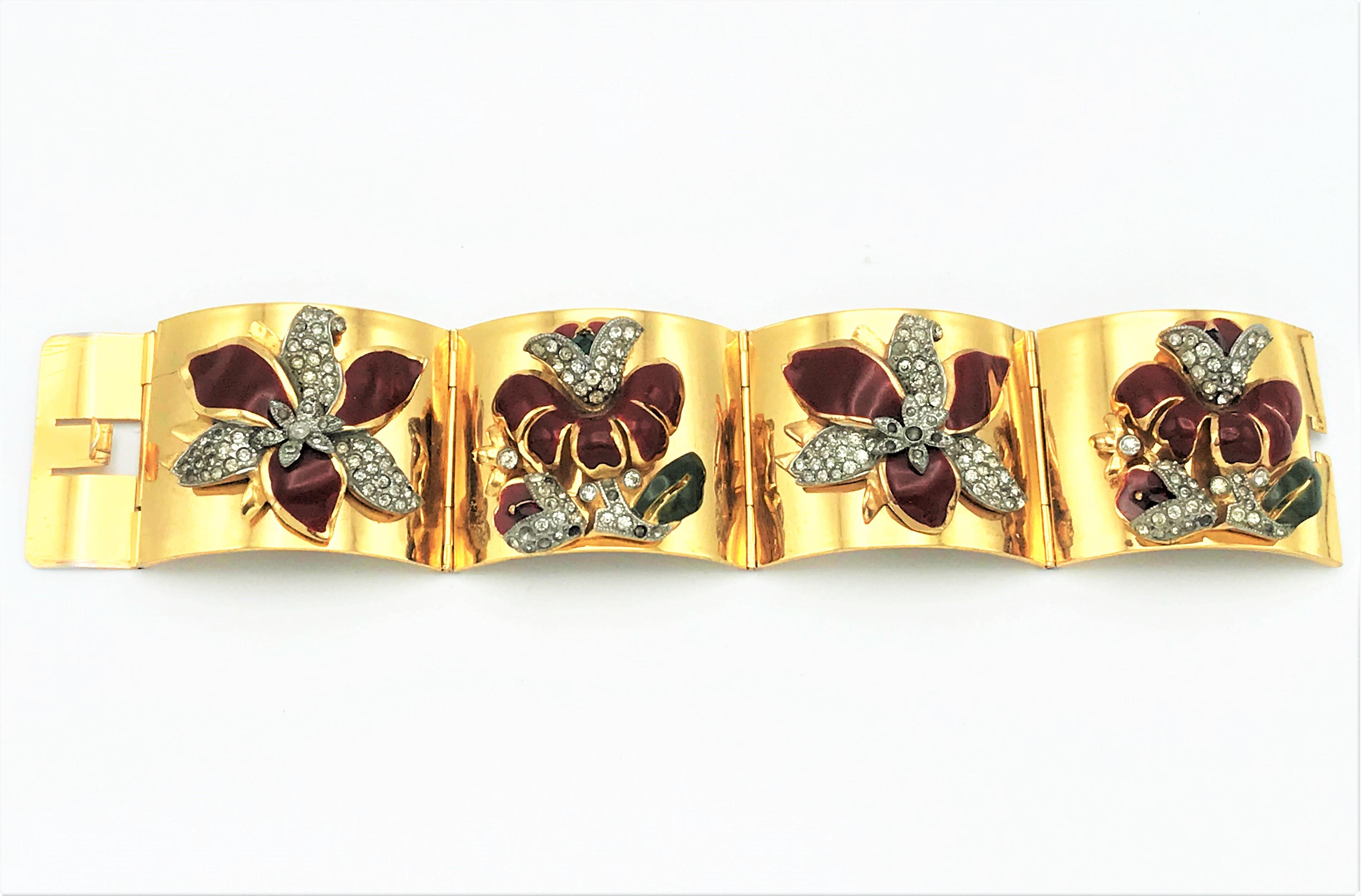 4-link gold plated bracelet. Each link part has an enameled red-brown flower with green leaves and flowers and leaves set with rhinestones attached. There are Duett brooches from Coro that are set with 2 of these flowers. It must be an unsigned