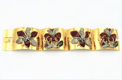 Gold plated hinged bracelet with Coro enamel flowers attached from the 1940s, US