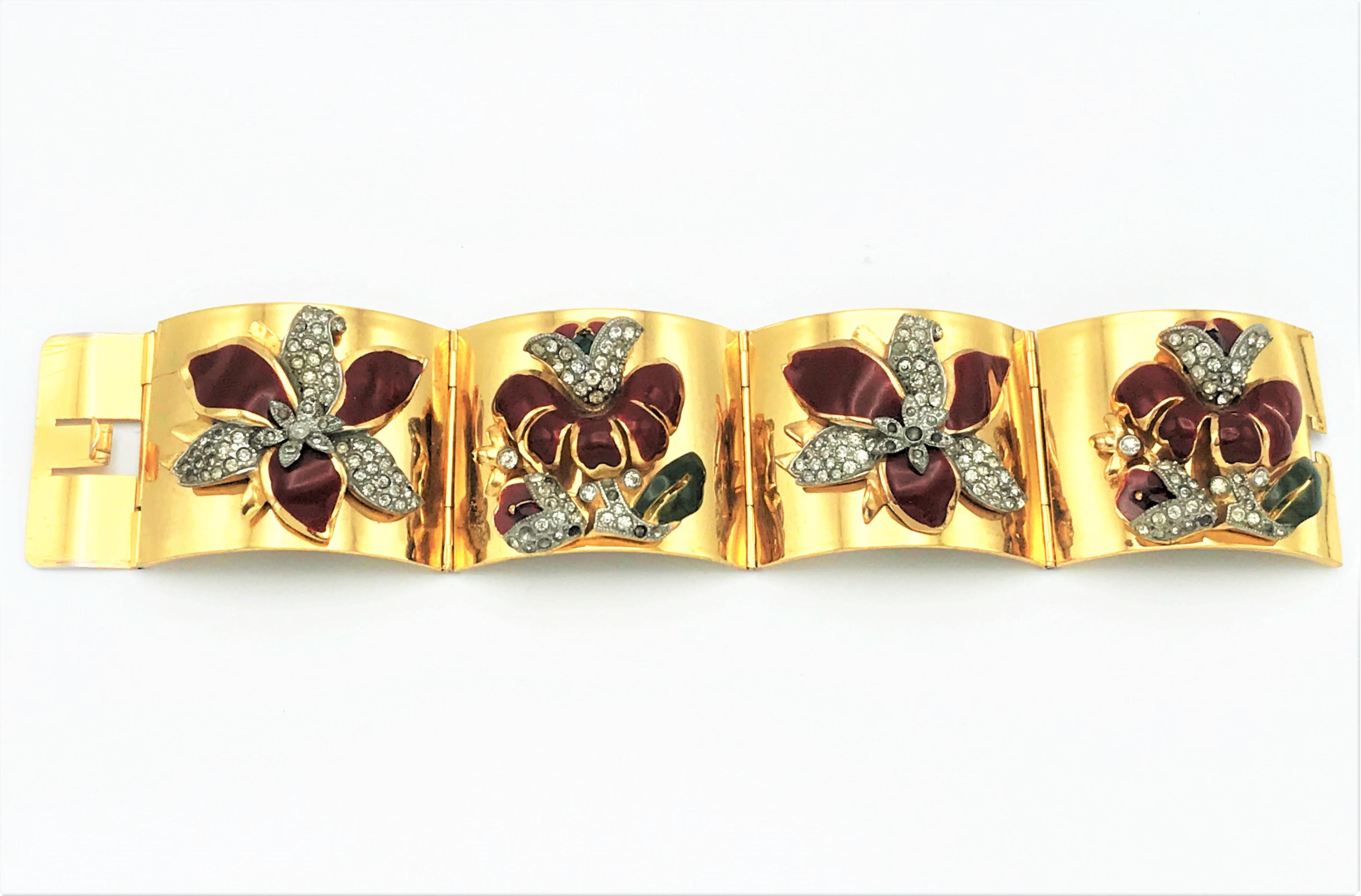 Gold plated hinged CORO bracelet with enamel flowers attached from the 1940s earea USA.

Dimensions
Width of the bracelet 4 cm 
Length                       19 cm 
Size of the enamel flowers 

