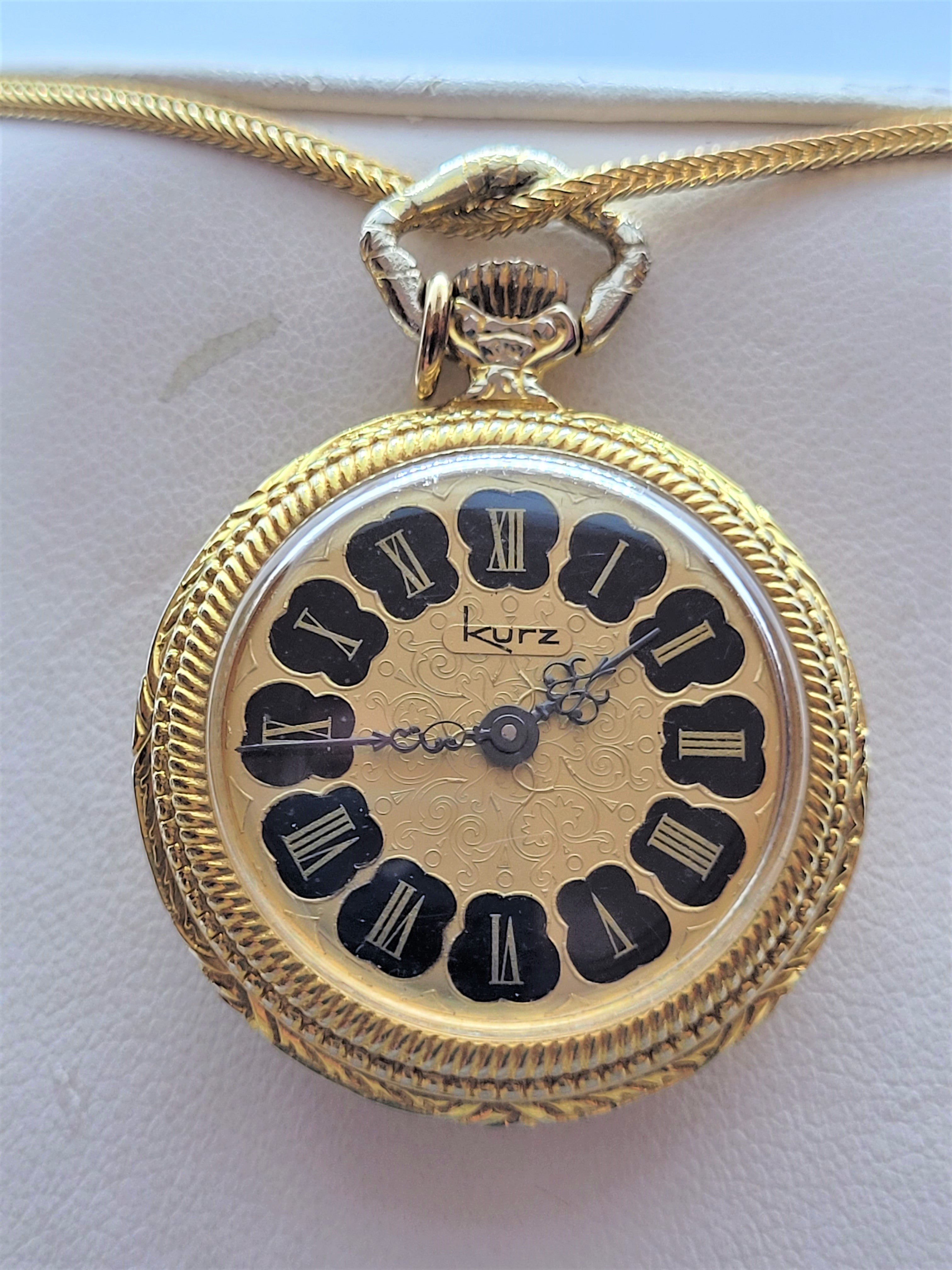 Beautiful gold plated Kurz watch pendant with original box. The 30mm watch case (11mm thick) has a lovely black and gold scroll design. On the backside of the watch, there's an image of a man playing the guitar for ladies. Overall, the condition of