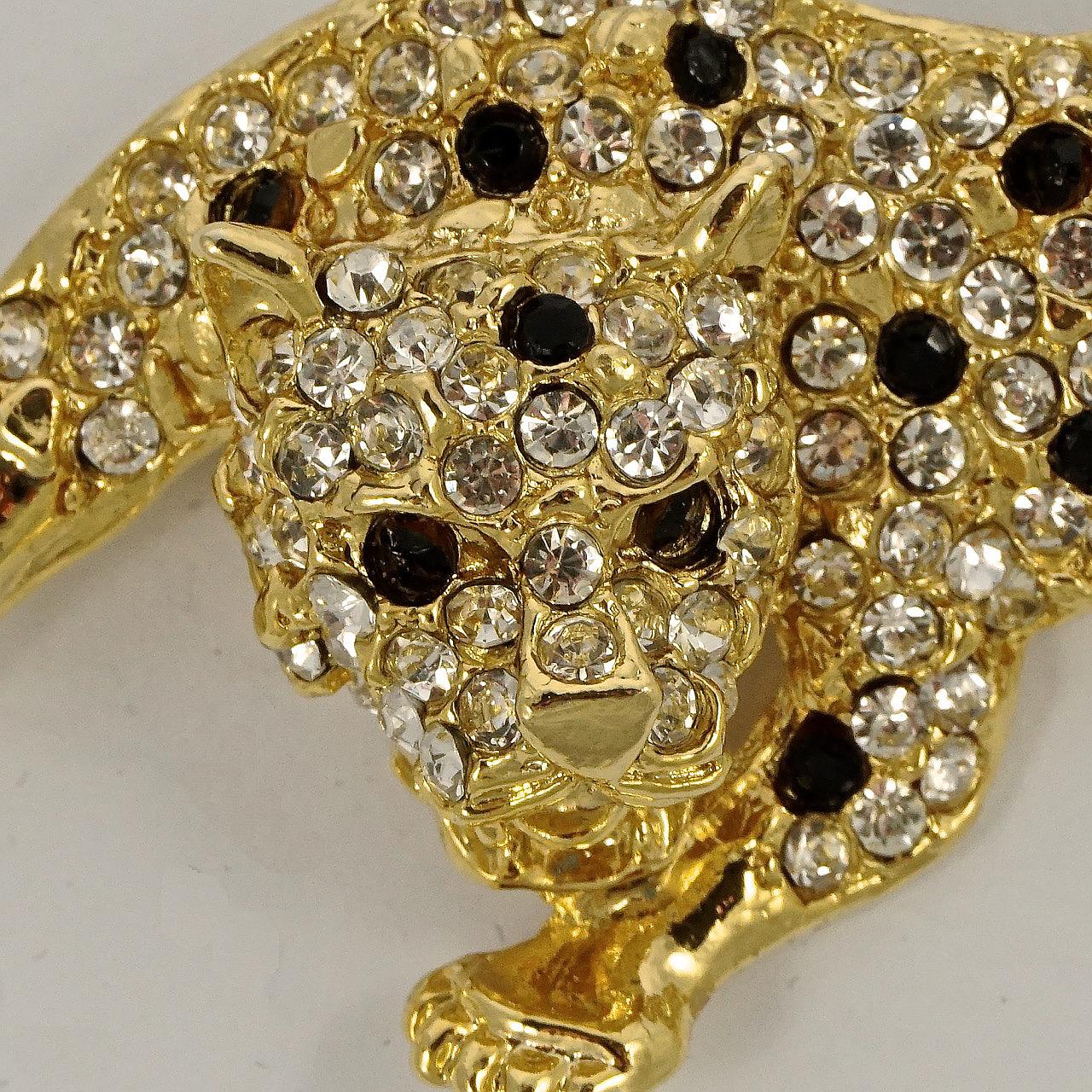 Stylish gold plated leopard brooch, featuring faceted black and clear rhinestones. Measuring length 6.8cm / 2.67 inches by width 3.3cm / 1.3 inches. The brooch is in very good condition.

This beautiful leopard brooch is circa 1980s.
