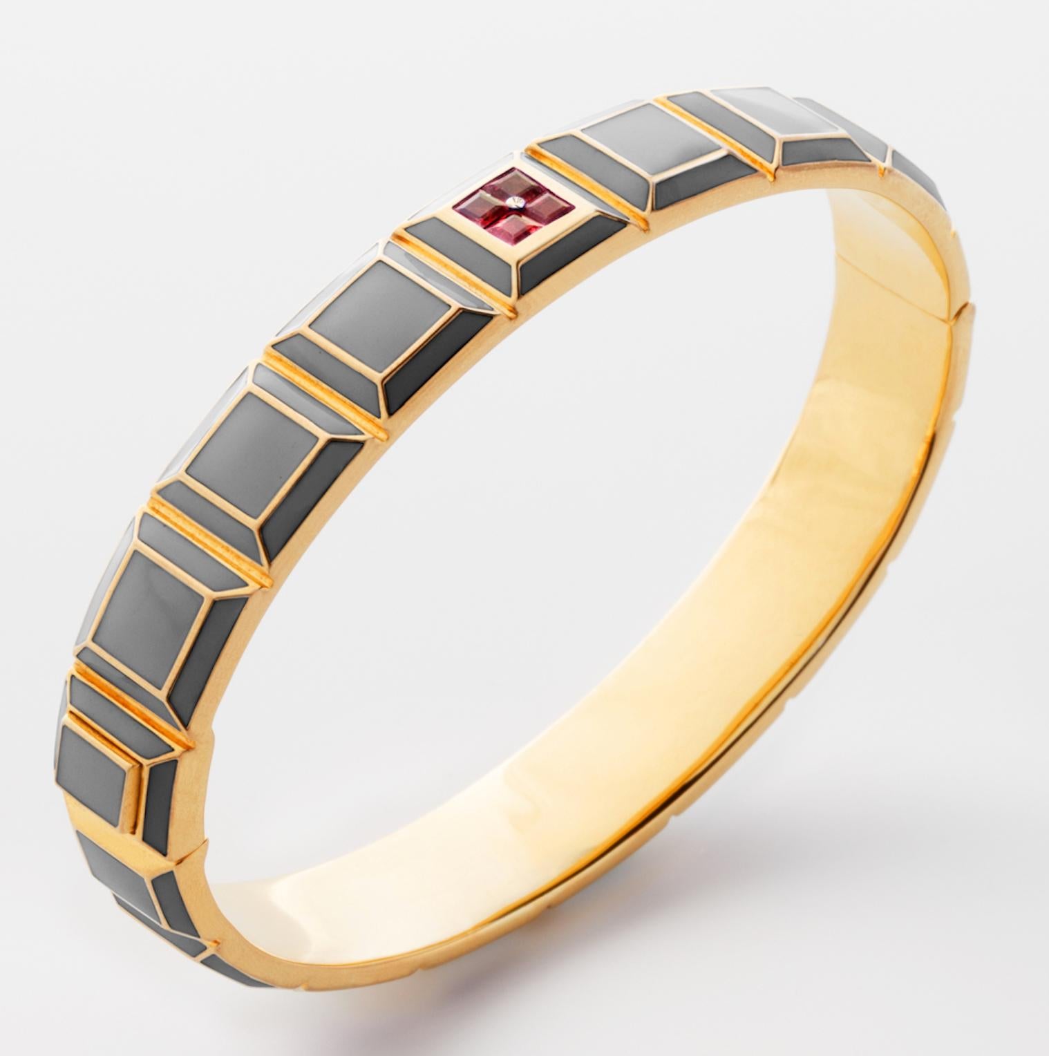 Gold-Plated Enamel Carousel Bracelet features a Yellow Gold-Plated Silver bracelet with Light Grey Enamel and Rubies, along with a clasp closure that secures the bracelet onto the wearer's wrist. 
Yellow Gold-Plated Silver, Light Grey Enamel, Rubies