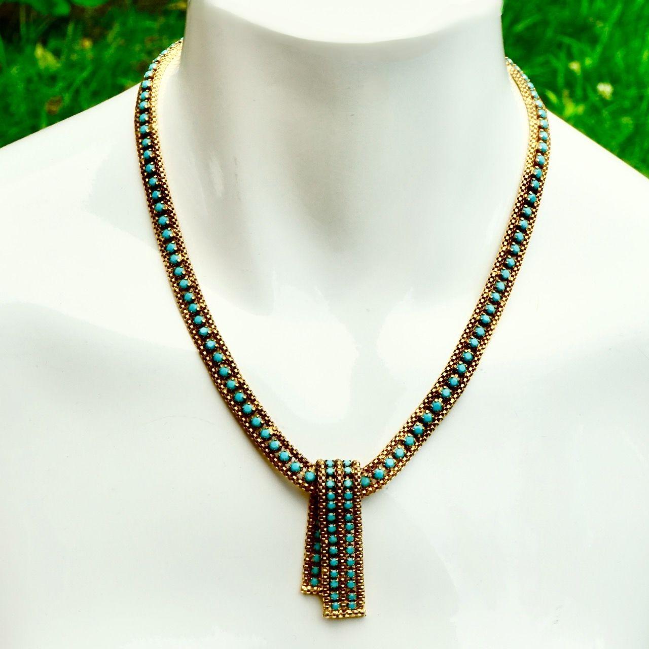 Deliziosa collana in maglia placcata oro con pietre di vetro finto turchese sfaccettate e ciondolo pieghevole. Lunghezza 42 cm / 16,5 pollici per una larghezza di 8 mm / .3 pollici, con un'estensione di 5,5 cm / 2,1 pollici. La placcatura in oro è