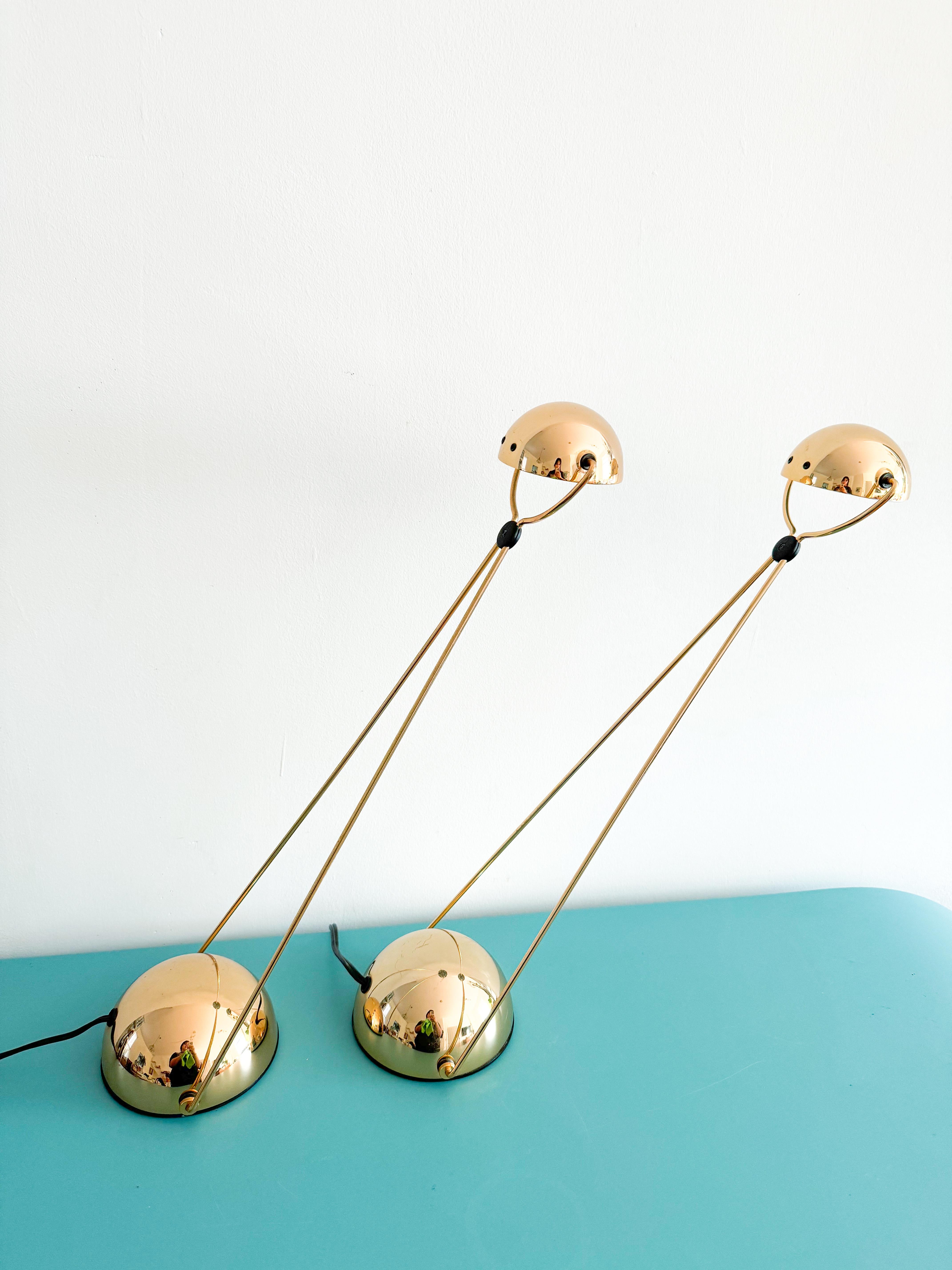 Pair of postmodern adjustable desk lamps by Stefano Cevoli, originating from Milano, Italy, in the 1980s. 
Crafted with a striking blend of bold gold accents and sleek black elements, these lamps showcase a refined, architectural aesthetic with a
