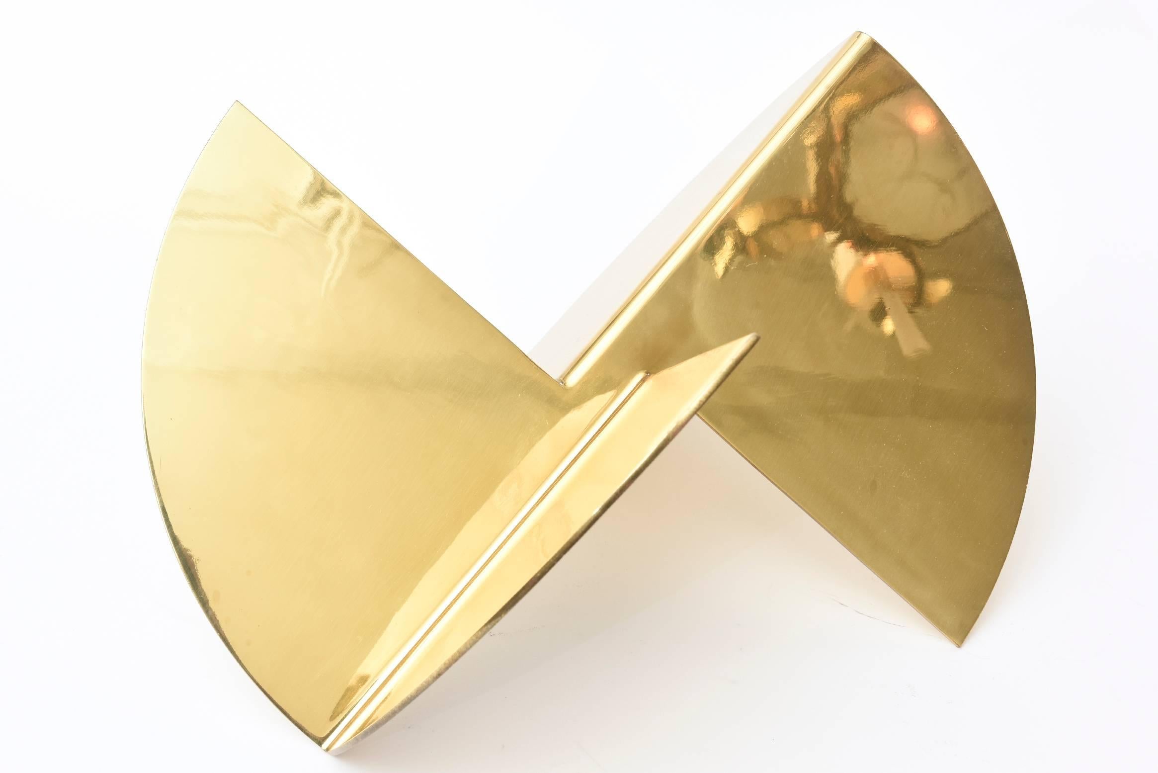 This wonderful gold-plated abstract geometric modern sculpture is almost like a work in origami of four intersecting planes of simple forms. It is a great tabletop sculpture that with each angle represents a new viewpoint and abstraction.
It has