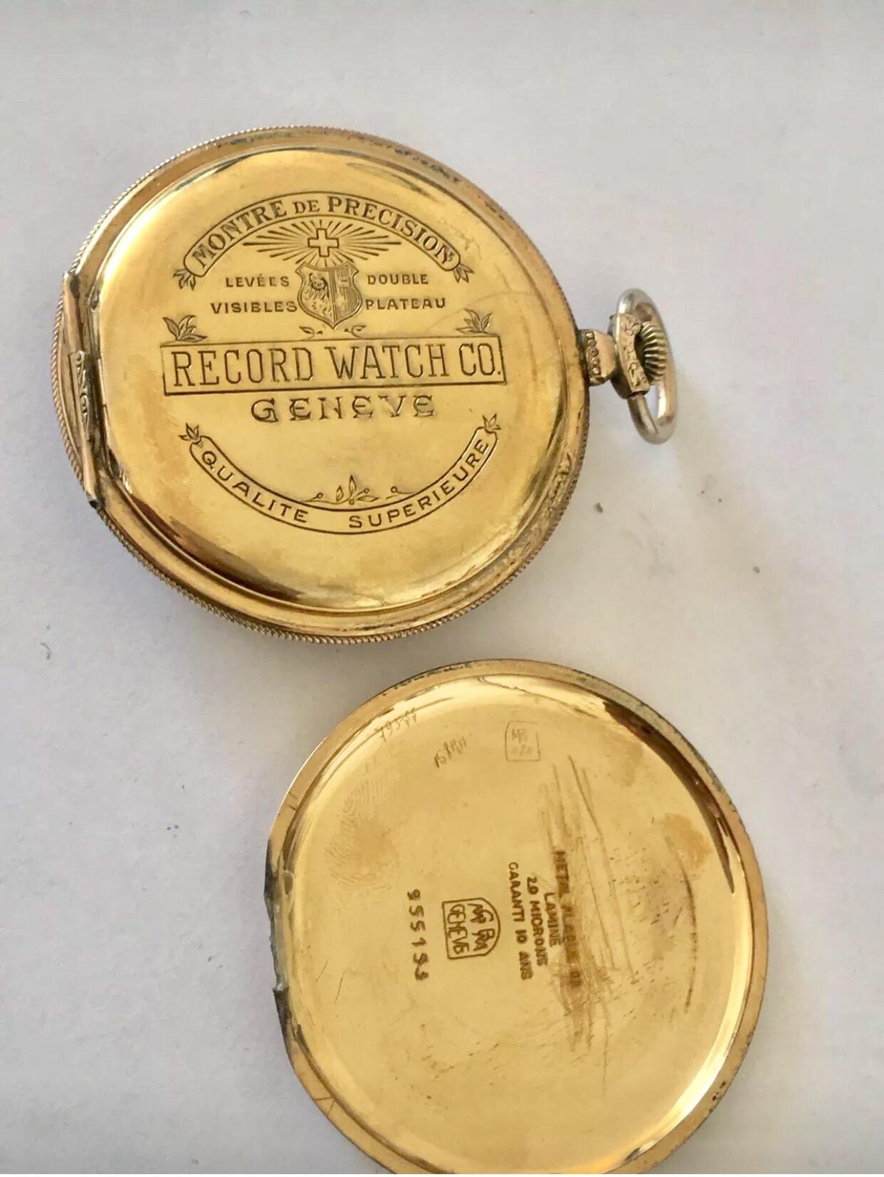 Antique Gold Plated Record Watch Co. Montre de poche Geneve Dress.

Cette belle montre est en bon état de marche et son tic-tac est bon. Signes visibles de vieillissement et d'usure avec de légères éraflures sur le boîtier. Le cadran argenté a