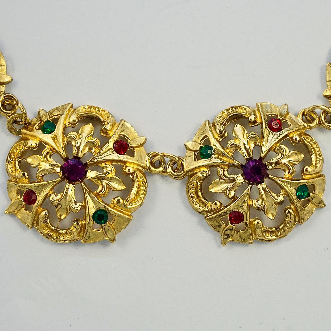 Fabuloso collar de estilo renacentista chapado en oro, con joyas de cristal rojo, verde y morado engastadas en eslabones ornamentados. Mide 45 cm de largo por 2,8 cm de ancho. El collar está en muy buen estado. El chapado en oro está algo desgastado