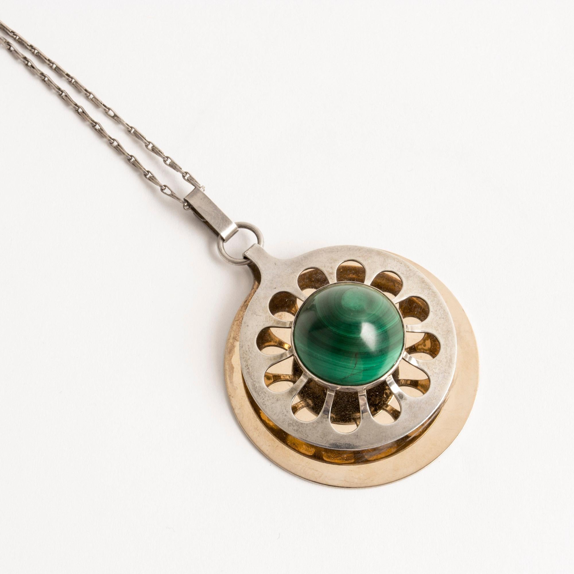 Rare gold plated silver necklace by Theresia Hvorslev. A large round cut malachite is the focal point, framed by cut out out petals. Beautifully executed.

Dimensions: Diameter of pendant 4.2 cm, length of chain 68 cm