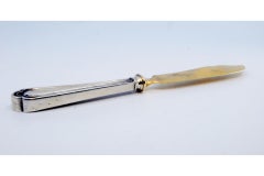 Gold-plated silver cheese knife with grooves along the handle