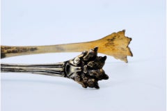 Gold-plated silver ice tongs in the shape of claws and reliefs on both sides