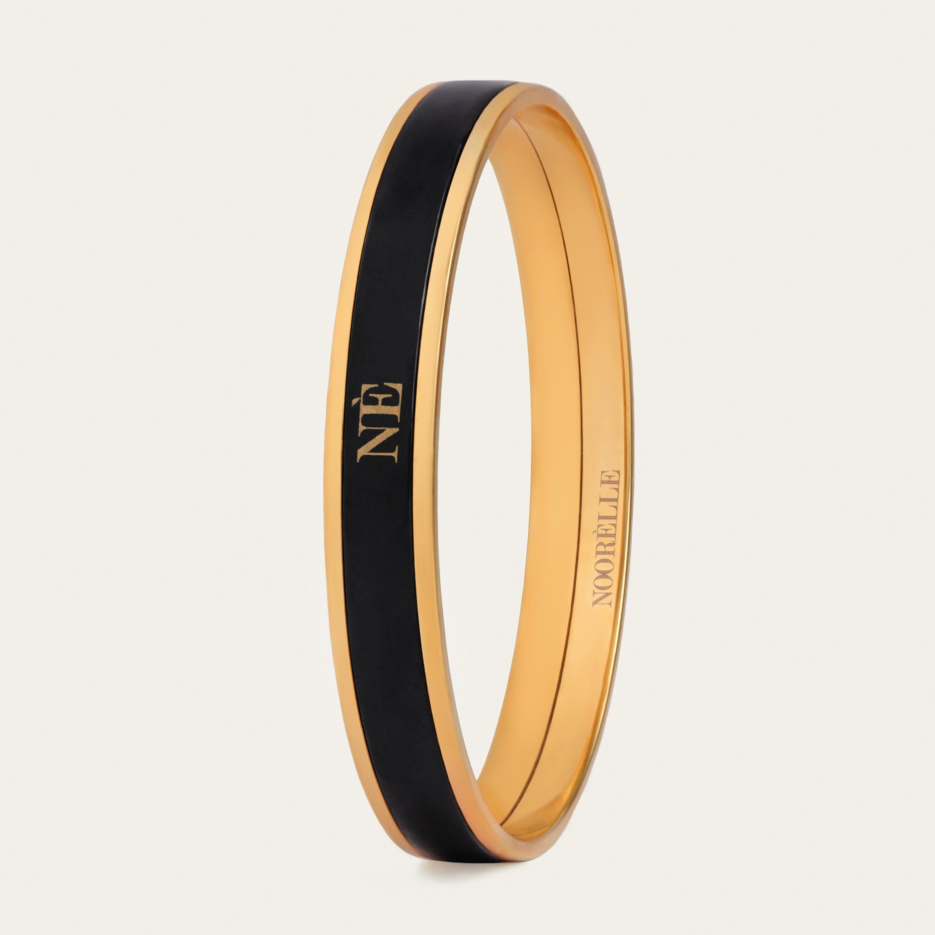 Presenting the Monochrome Bangle in Black! Elevate your style with our exquisite 18k gold-plated stainless steel bangle. Hand-painted with genuine fire enamel in vivid colors that will last forever, this luxurious piece is designed to make a