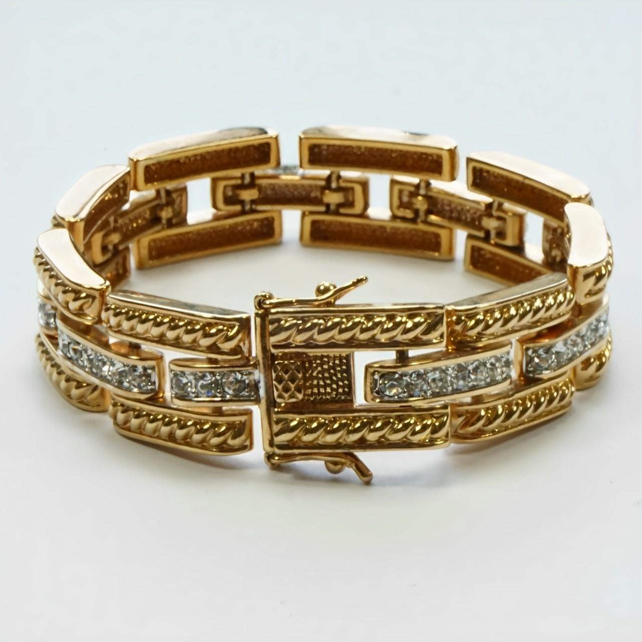 Bracciale a maglie stile carrarmato placcato in oro, con intreccio di corde e decorazione di strass. Il colore dell'oro è leggermente rosato. Lunghezza 19 cm / 7,5 pollici e larghezza 1,4 cm / .55 pollici. Il bracciale è in buone condizioni, con