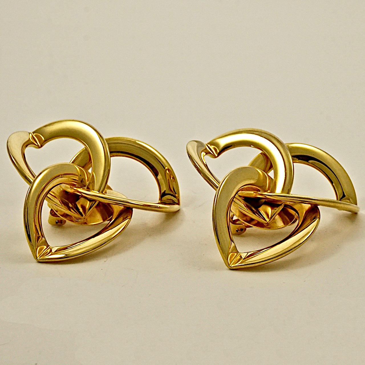 Gold plated clip on earrings, featuring intersecting triple hoops. Measuring diameter 4.8 cm / 1.88 inches. The earrings are in very good condition.

This is a pair of stylish vintage statement earrings from the 1980s.
