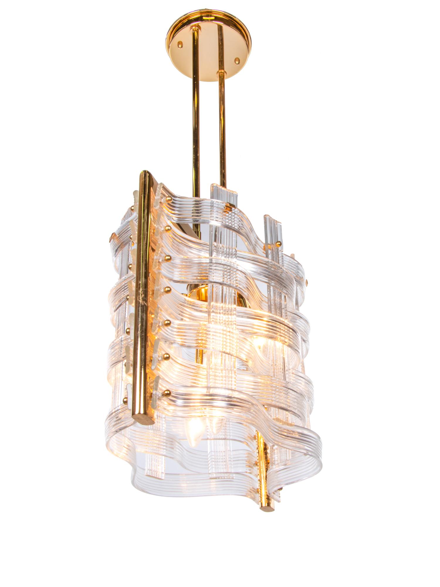 Elegant 'Nastri' chandelier from Venini with clear wave-shaped Murano glass ribbons on a gold-plated brass fitting. This wonderful and very elegant mid-century ceiling light has an incomparably unique character. Chandelier illuminates beautifully
