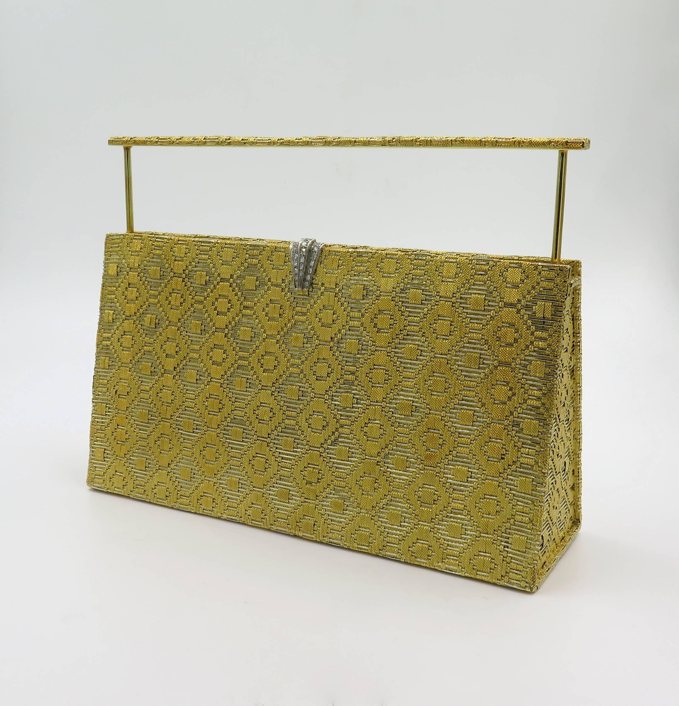 An 18 karat yellow gold, platinum and diamond minaudière. French. Circa 1950. the rectangular clutch of polished and woven gold design, with a pave set diamond closure, opening to reveal a mirror and comb, with hidden handle. With French maker’s