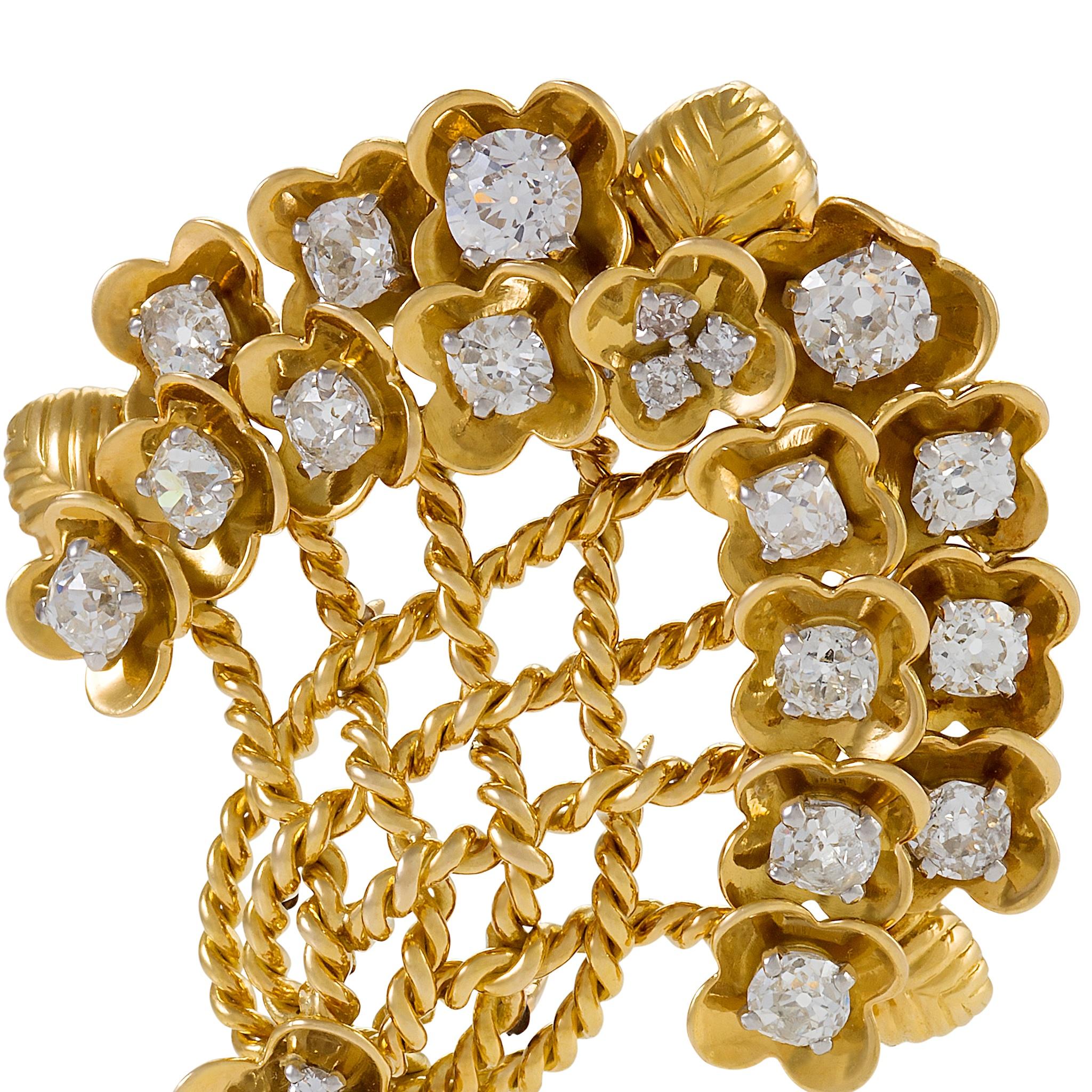 A French Retro 18 karat gold, platinum and diamond brooch by Cartier. The brooch is designed as a stylized flower bouquet, decorated with 21 Old European-cut and cushion-shaped diamonds that have the approximate total weight of 5.00 carats. The