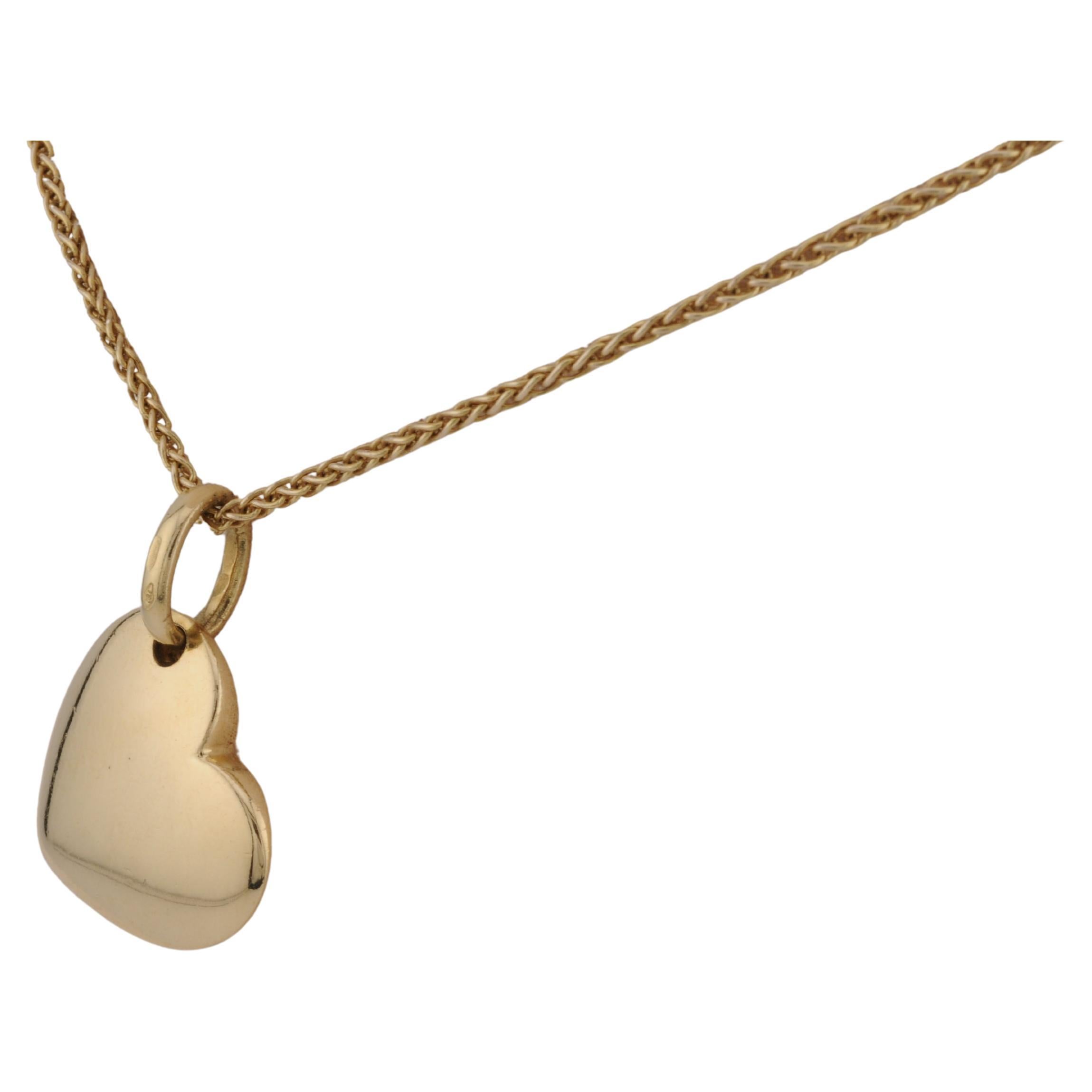 Pendentif en or jaune 18 carats, conçu par Pomellato, en forme de cœur stylisé. Le design est simple et élégant, avec une surface lisse qui met en valeur la beauté de l'or. Le pendentif reflète le savoir-faire artisanal de Pomellato et convient à