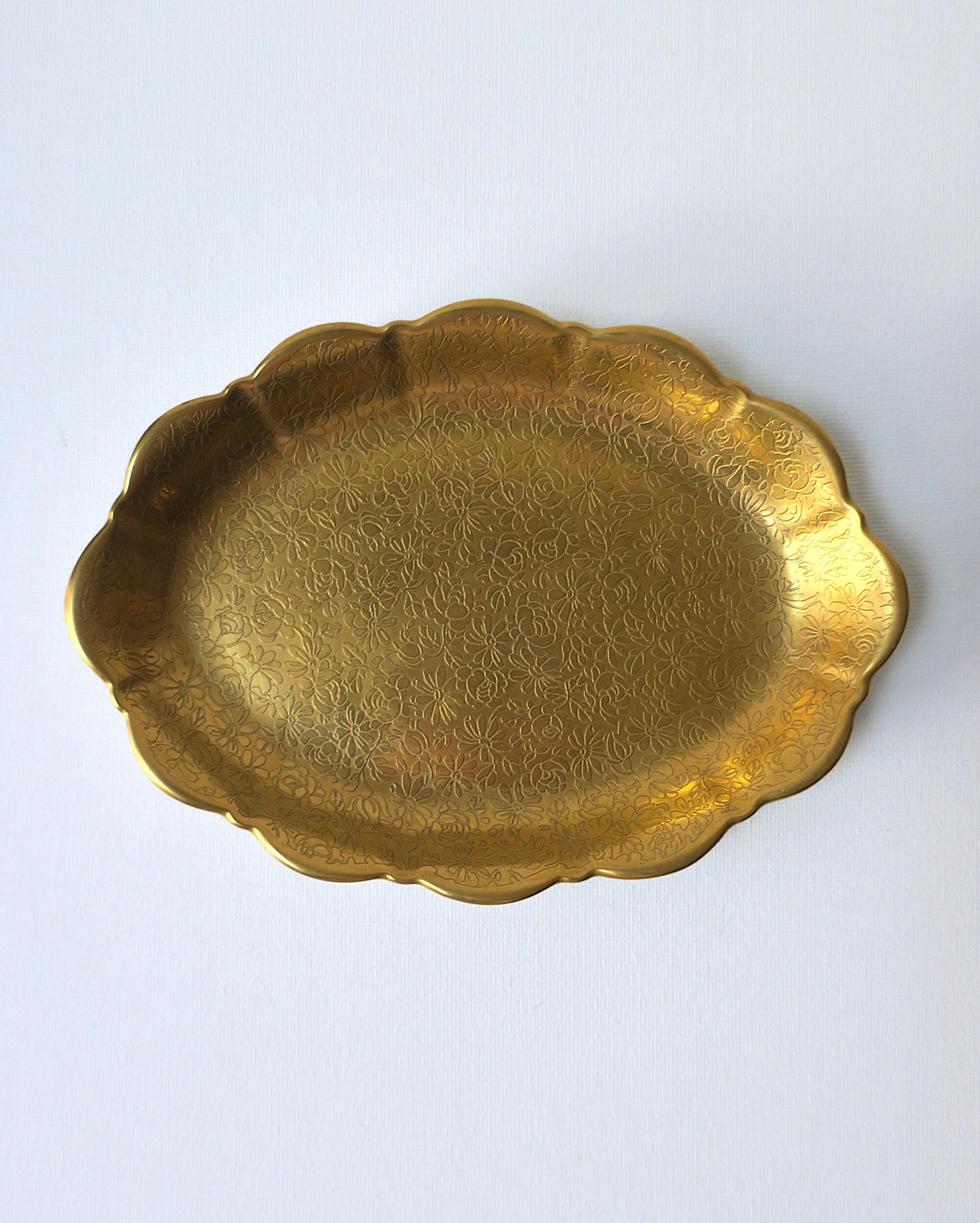 An oval scalloped edge porcelain jewelry dish with a hand-decorated rich gold finish of embossed flower design, circa mid to late-20th century, made in USA. A beautiful dish to hold small items (e.g. jewelry, etc.) on a vanity, dresser, nightstand