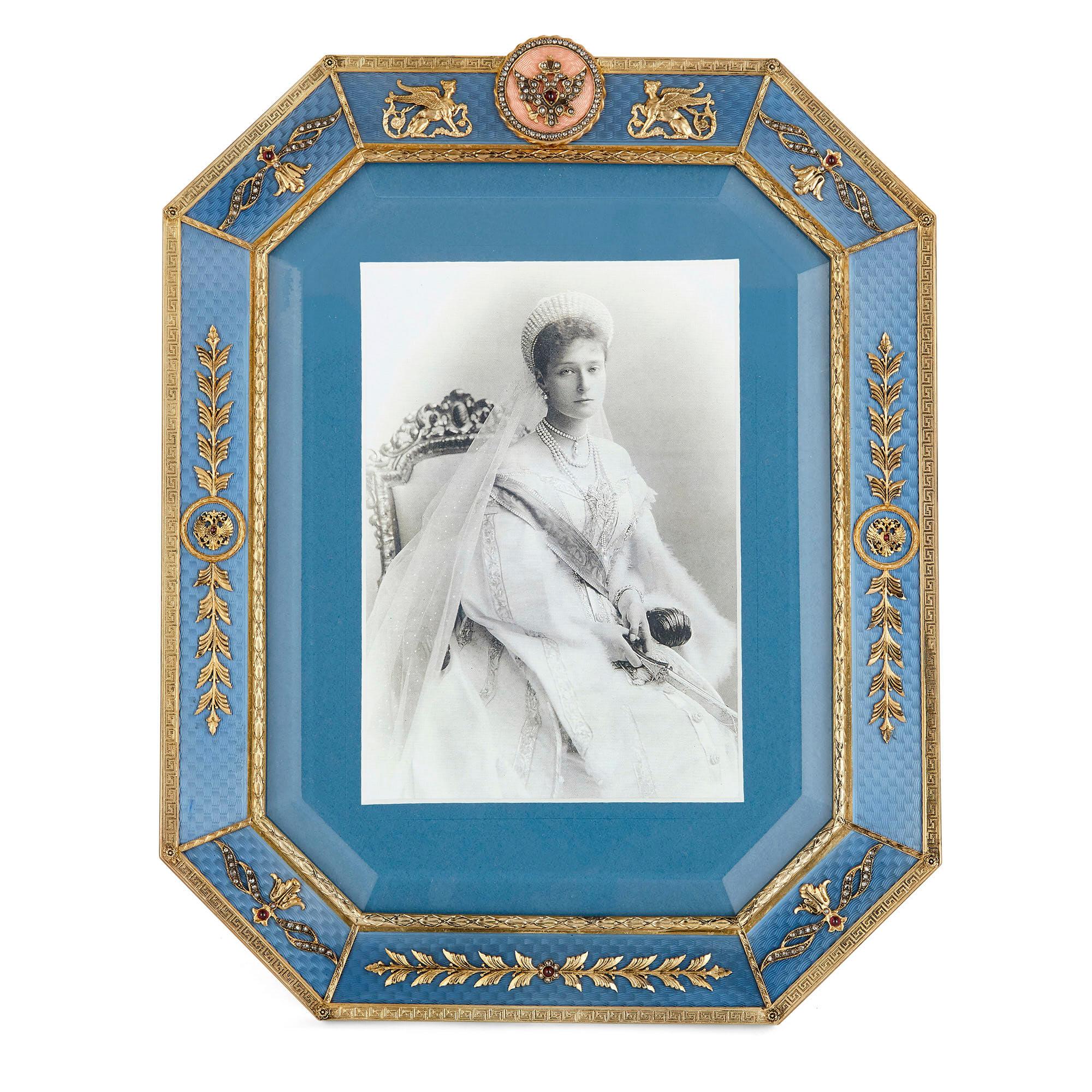 This picture frame is designed in the style of Fabergé. The frame is rectangular in profile with chamfered corners. The surface of the frame is profusely ornamented with guilloché enamel in a bright blue, the interior and exterior edge of the enamel