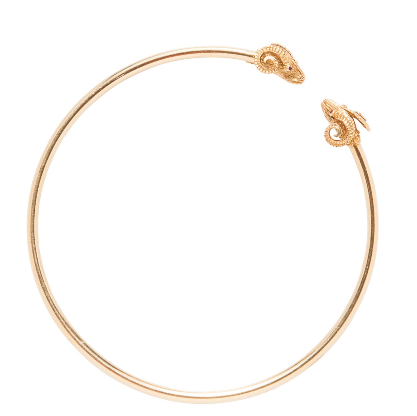 18 karat yellow gold flexible torque necklace featuring Ram head terminals with Ruby eyes, 1.80mm.  31.5 grams. Stamped 