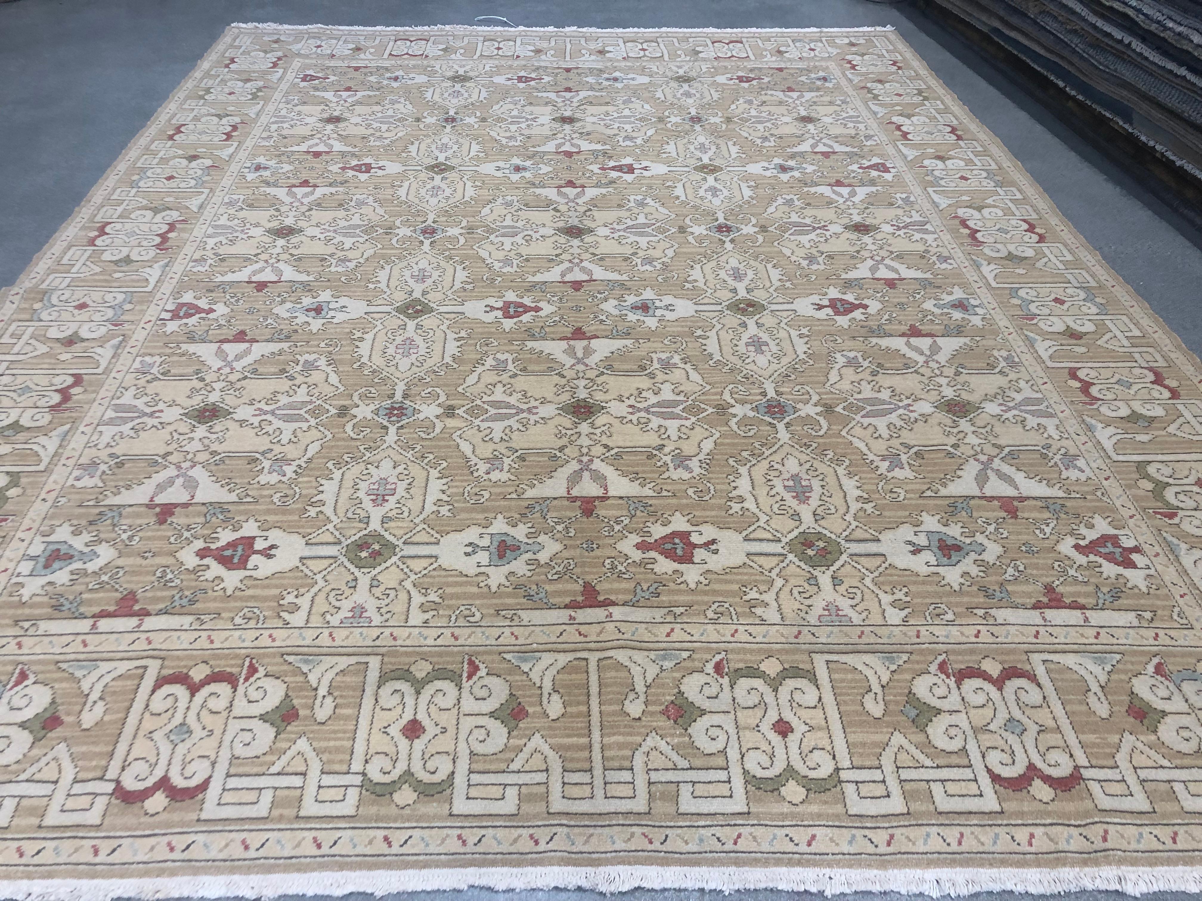 A traditional design receives a contemporary treatment in this deftly executed intricate patterned rug. Red, blue, green, yellow, beige and taupe against a tan background. Handmade in Europe. Wool.
