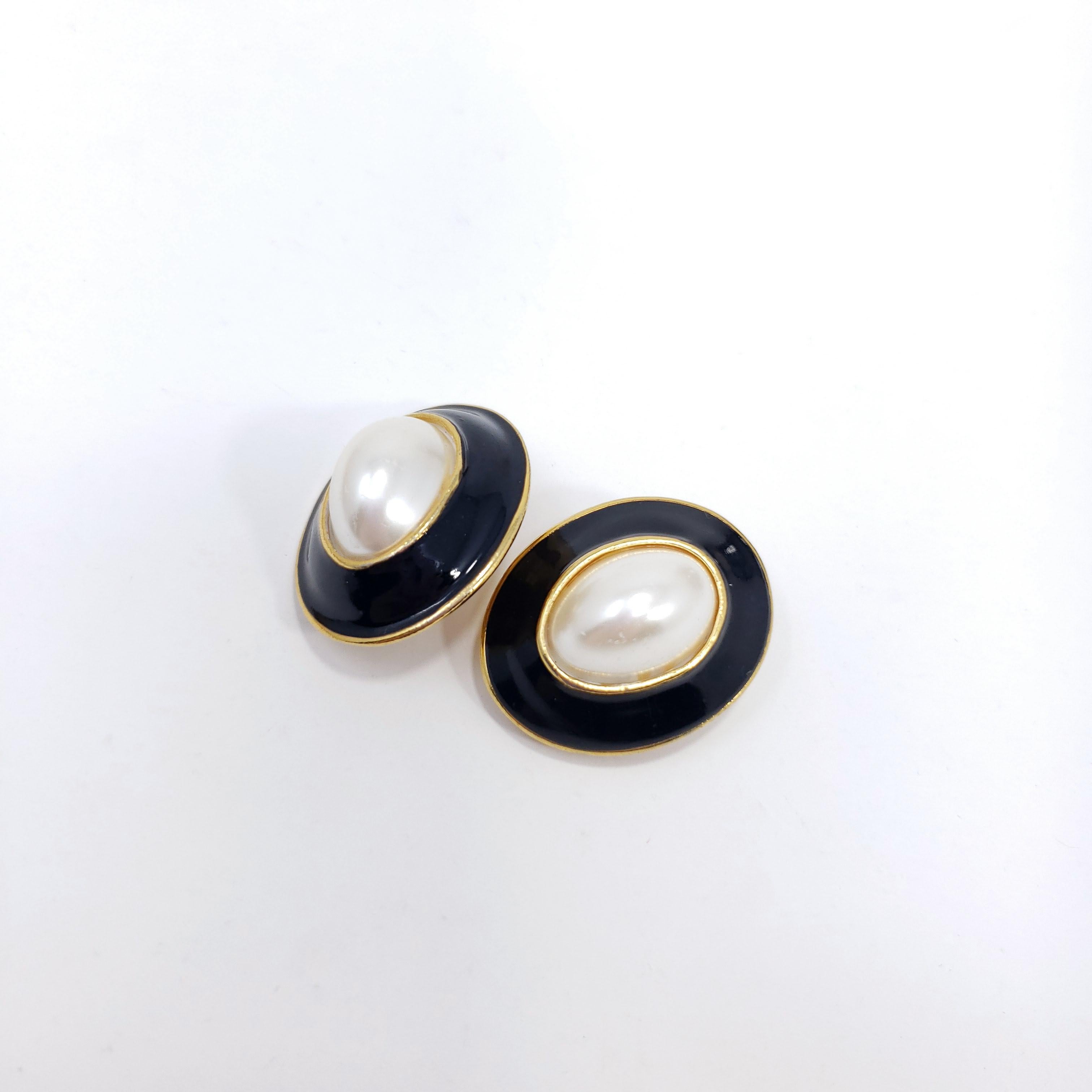 Big and bold, a pair of chunky clip on earrings. Stylish retro flair!

Black enamel and faux pearl center cabochon. Gold plated.

Late 1900s.