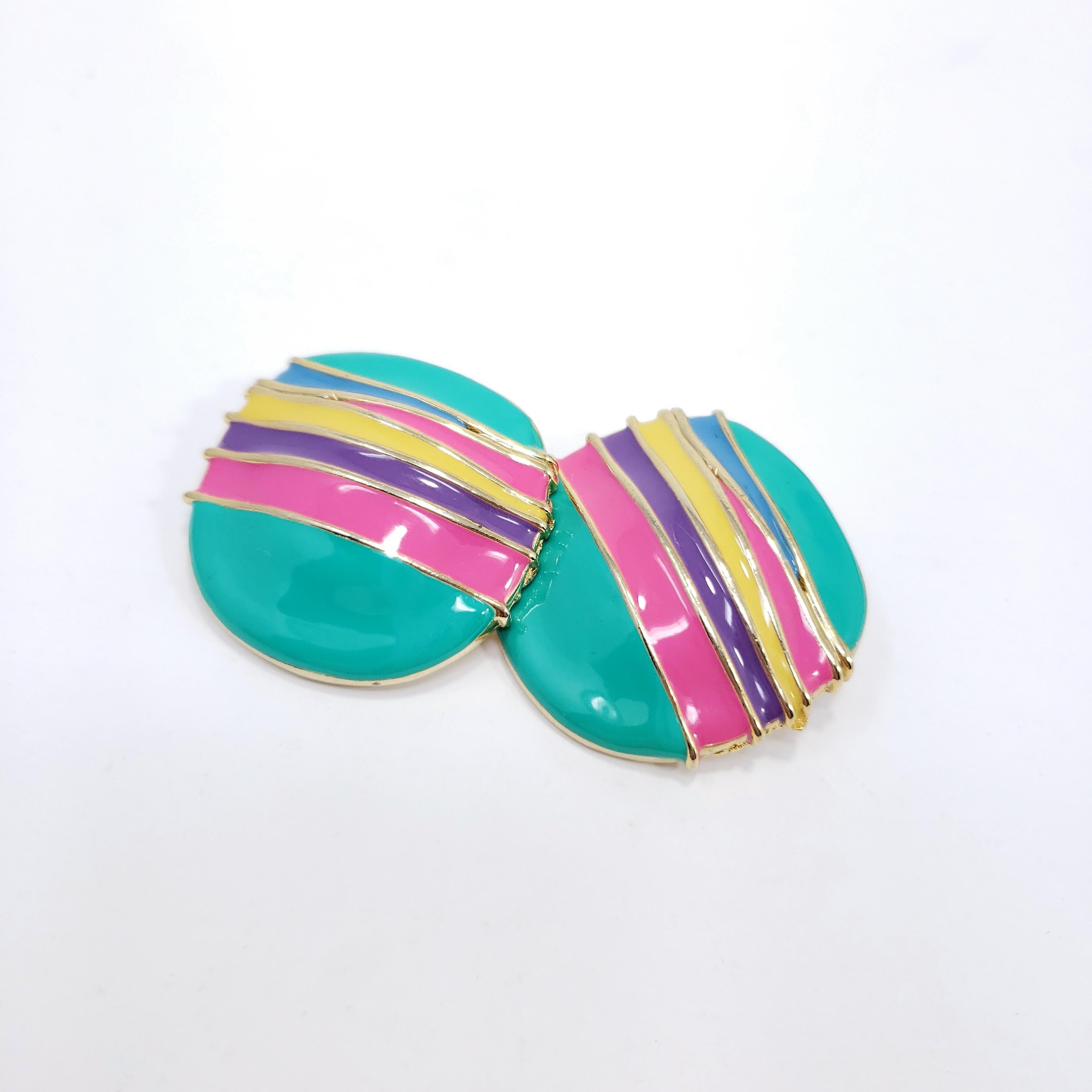 Big and bold, a pair of chunky hippie clip on earrings. The perfect retro accessory with a playful touch!

Turquoise, hot pink, violent, and yellow enamel.

Circa 1970s.

Gold-plated.