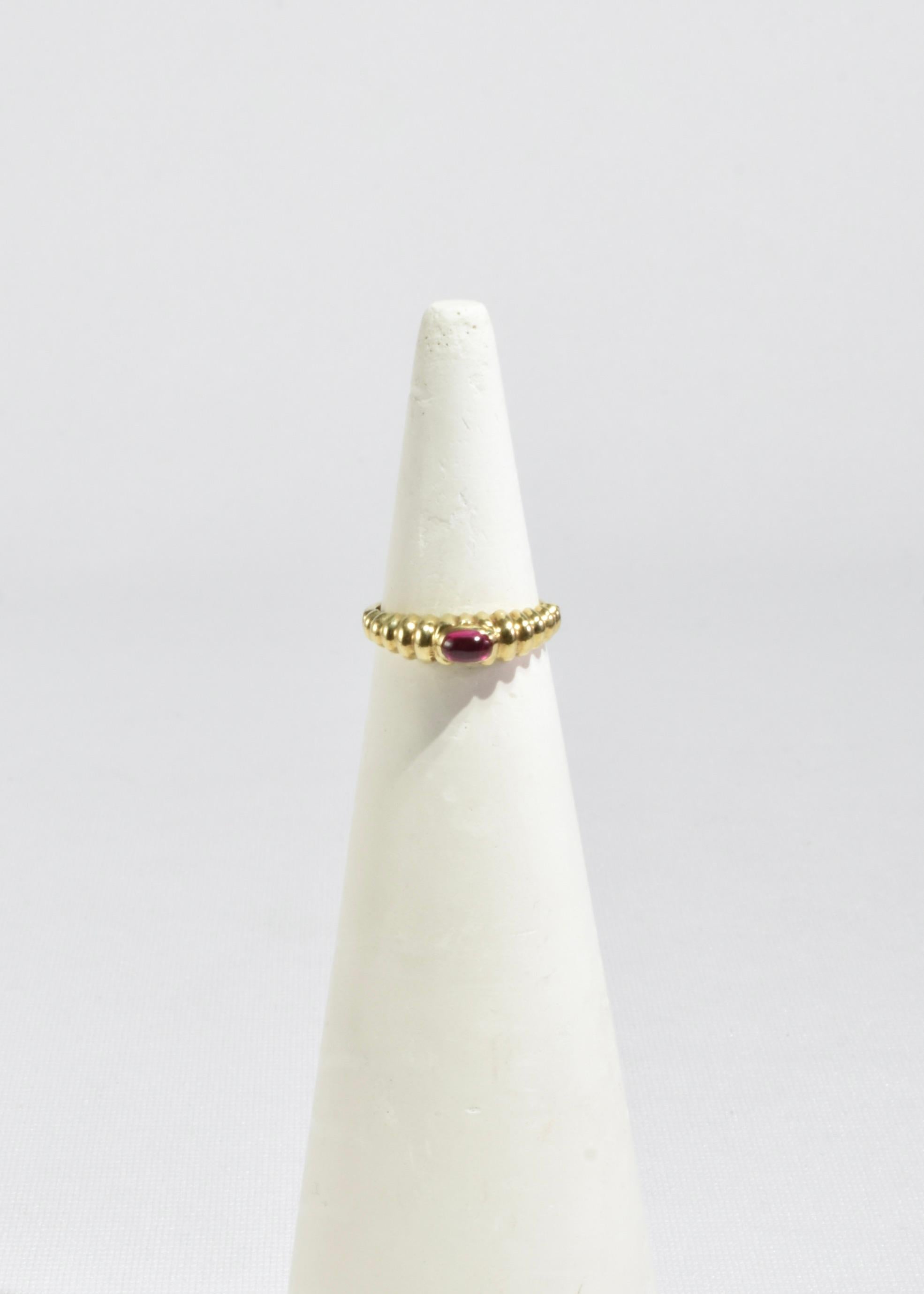 Stunning vintage gold ring with a ruby cabochon and ribbed detail. Stamped 14k.

Material: 14k gold, ruby.