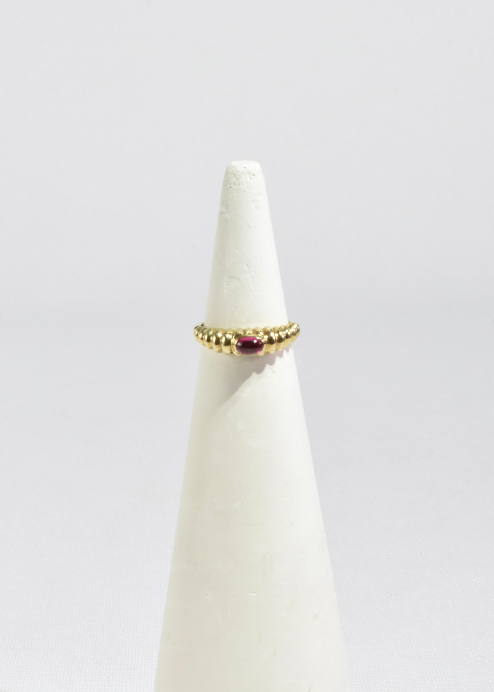 Impresionante anillo vintage de oro con un cabujón de rubí y detalle acanalado. Estampado 14k.

Material: Oro de 14 quilates, rubí.
