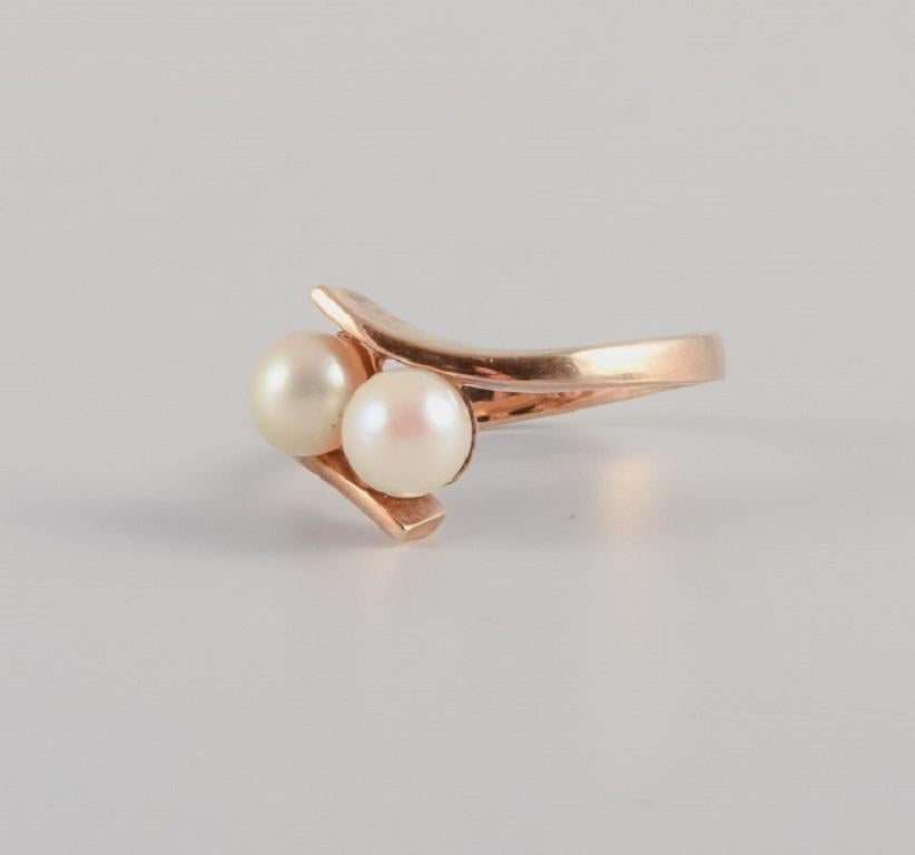 Gold ring adorned with two cultured pearls, Scandinavian goldsmith, approx. 1960s.
Stamped with the goldsmith's initials.
Measured at 14 carats.
In good condition.
Ring size 16 mm.
U.S. size 5.50

Our professional goldsmith, trained at Georg Jensen,