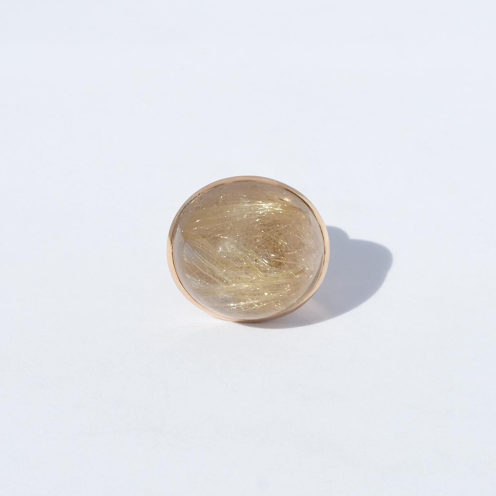 This 14 karat gold ring has a beautiful, clean and large golden rutile cabochon cut quartz stone with very distinct needle-like crystals.

The ring radiates power and attitude and is perfect for both the party and the every day use.