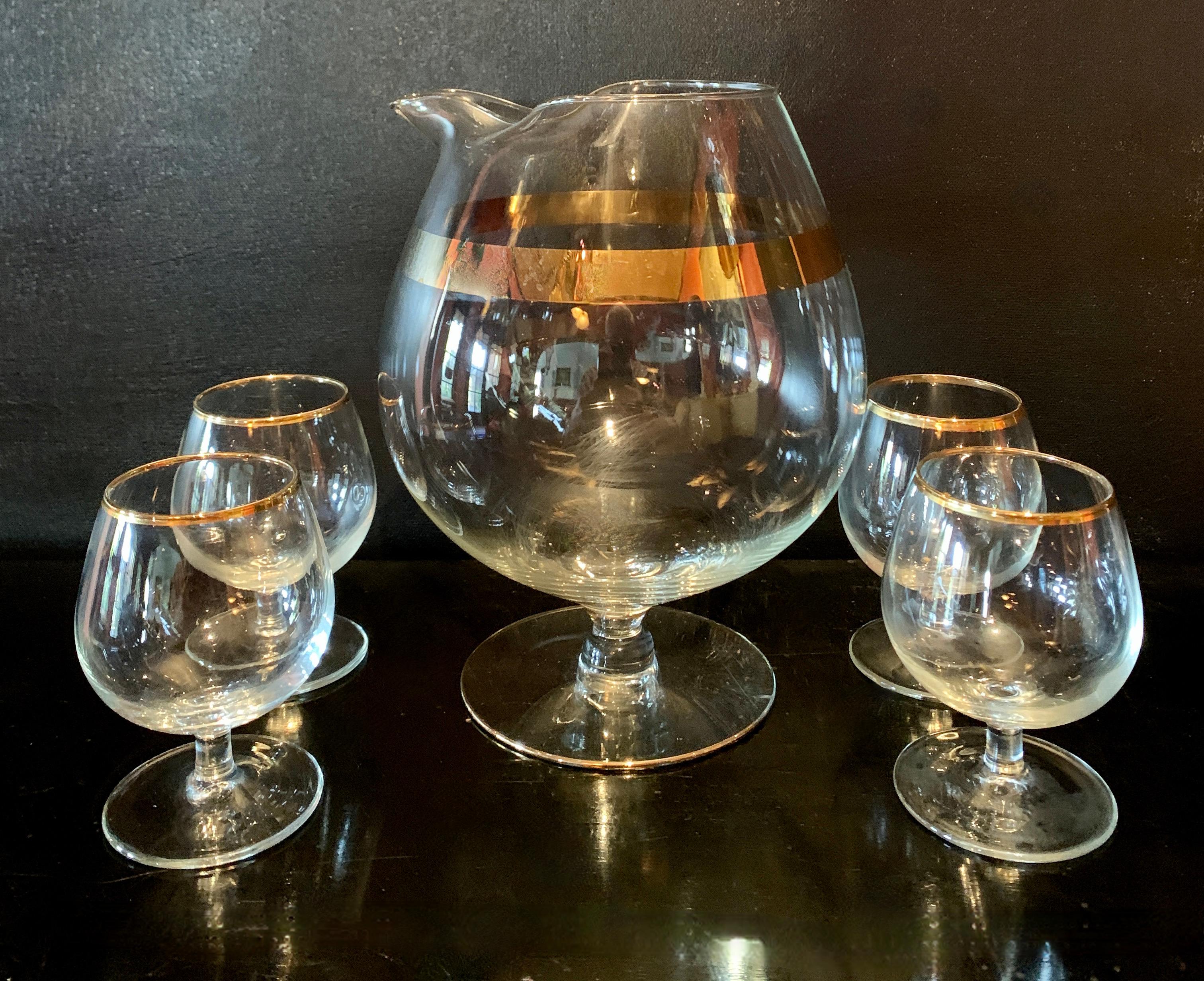 A lovely set of bar war. a Brandy Pitcher and glasses with gold rims - a compliment to any bar area.. very chic and ready to start the party. Hollywood Regency in the style of Dorothy Thorpe.