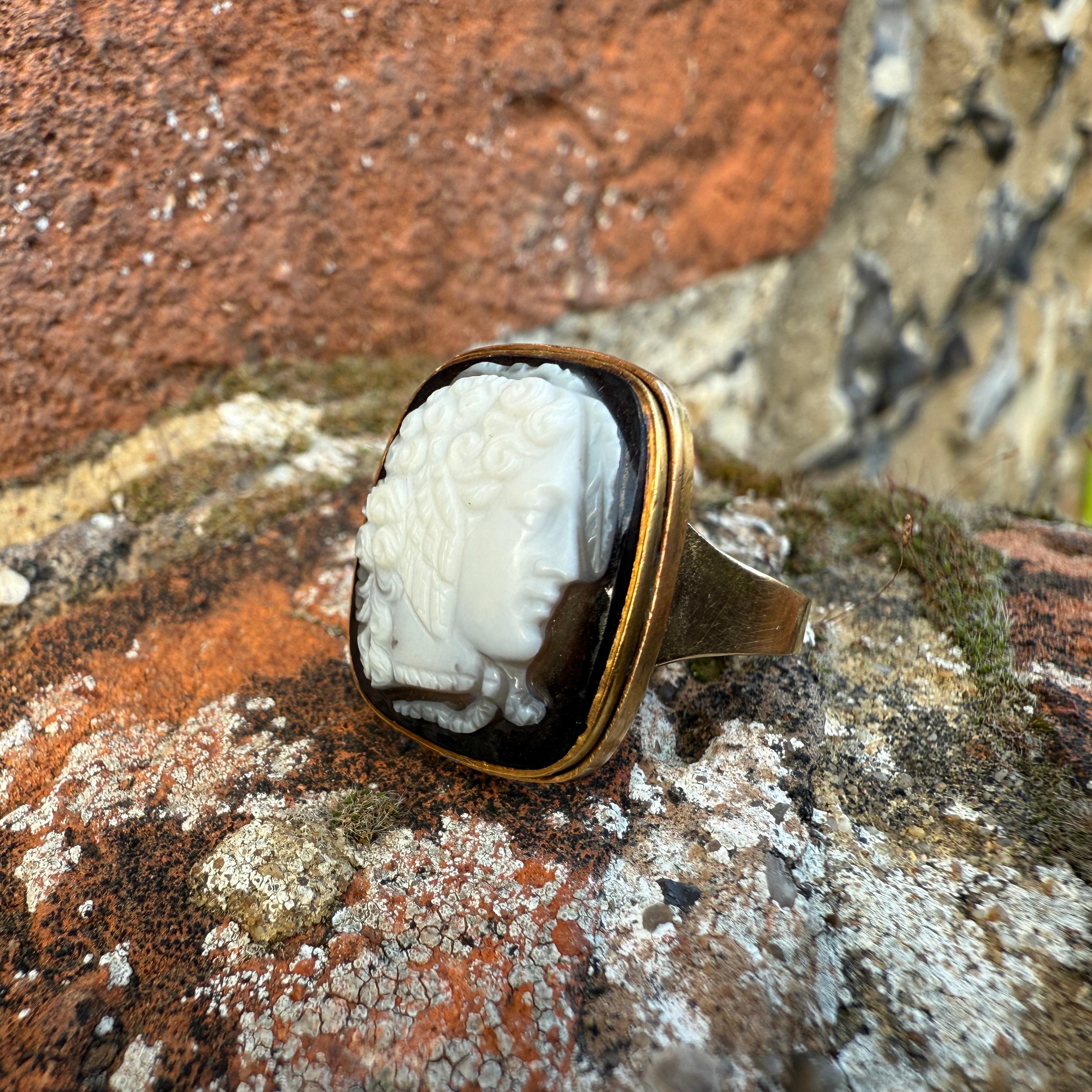 Gold Ring Set with a Sardonyx Cameo of Medusa.
 
The cameo 19th century, the ring later.
 
Measurements:
Bezel: 2 × 1.7cm.
Ring size: Q UK / 8 US / 57 EU.
Weight: 6.8 grams.
 
This high-carat gold ring is set with a finely carved sardonyx cameo