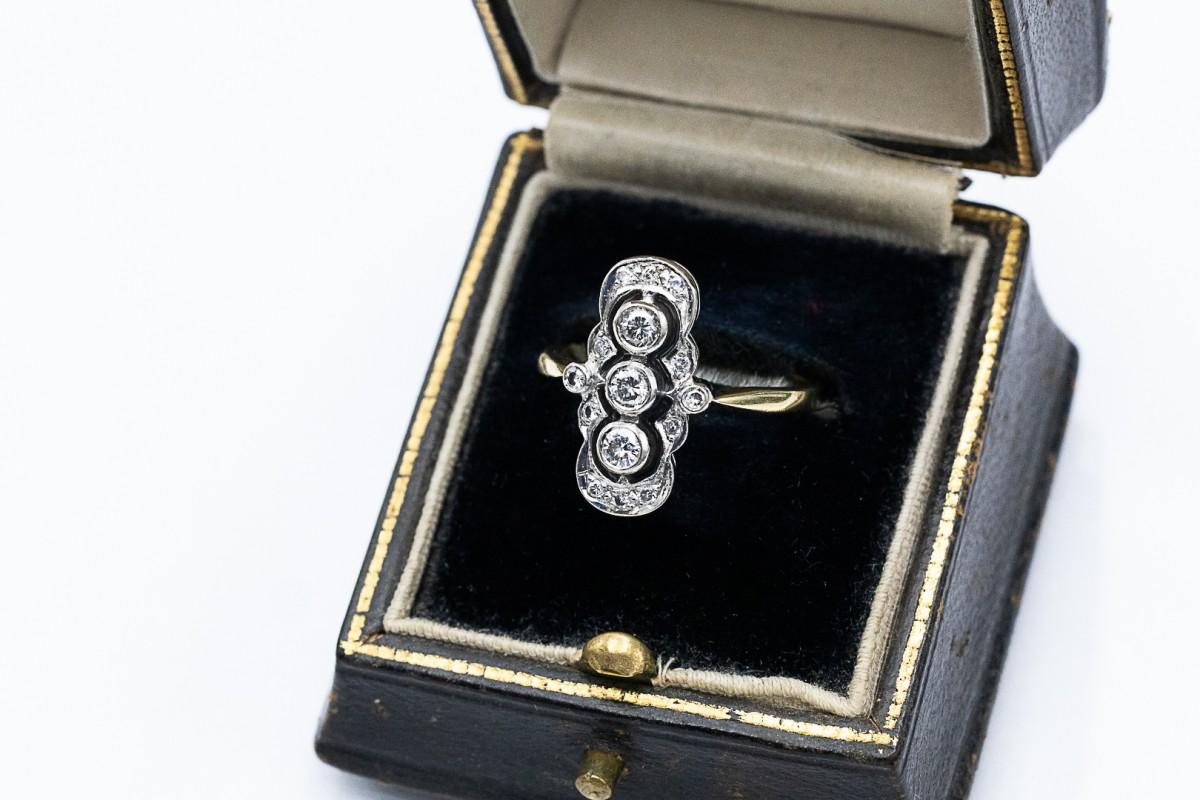 An elongated ring in the Art Deco style made of 18-karat gold (0.750 fineness).

Origin: Great Britain, Birmingham, 1991.

The front of the ring is decorated with 3 brilliant-cut diamonds with a total weight of approx. 0.25ct

Additionally, the ring