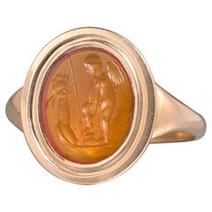 Anello in oro con incisione in corniola romana di Eros davanti a un altare.