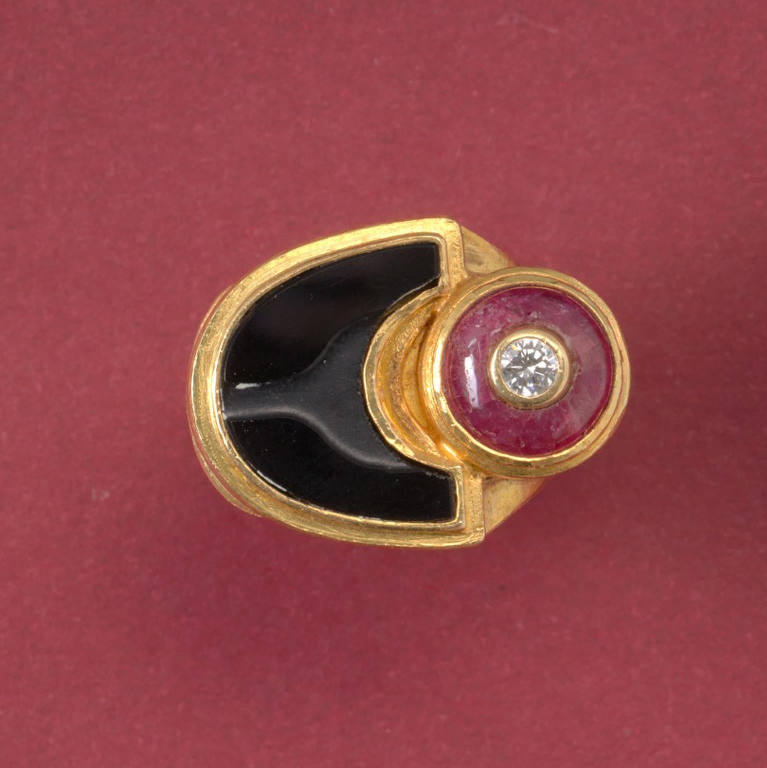 An 18 carat gold ring by Jacob de Groes set with a cabochon cut ruby incrusted with a brilliant cut diamond next to a flat textured moon shaped onyx.

weight: 19.12 gram
width: 6 - 18 mm.
ring size: 16 mm made smaller with gold balls so easily