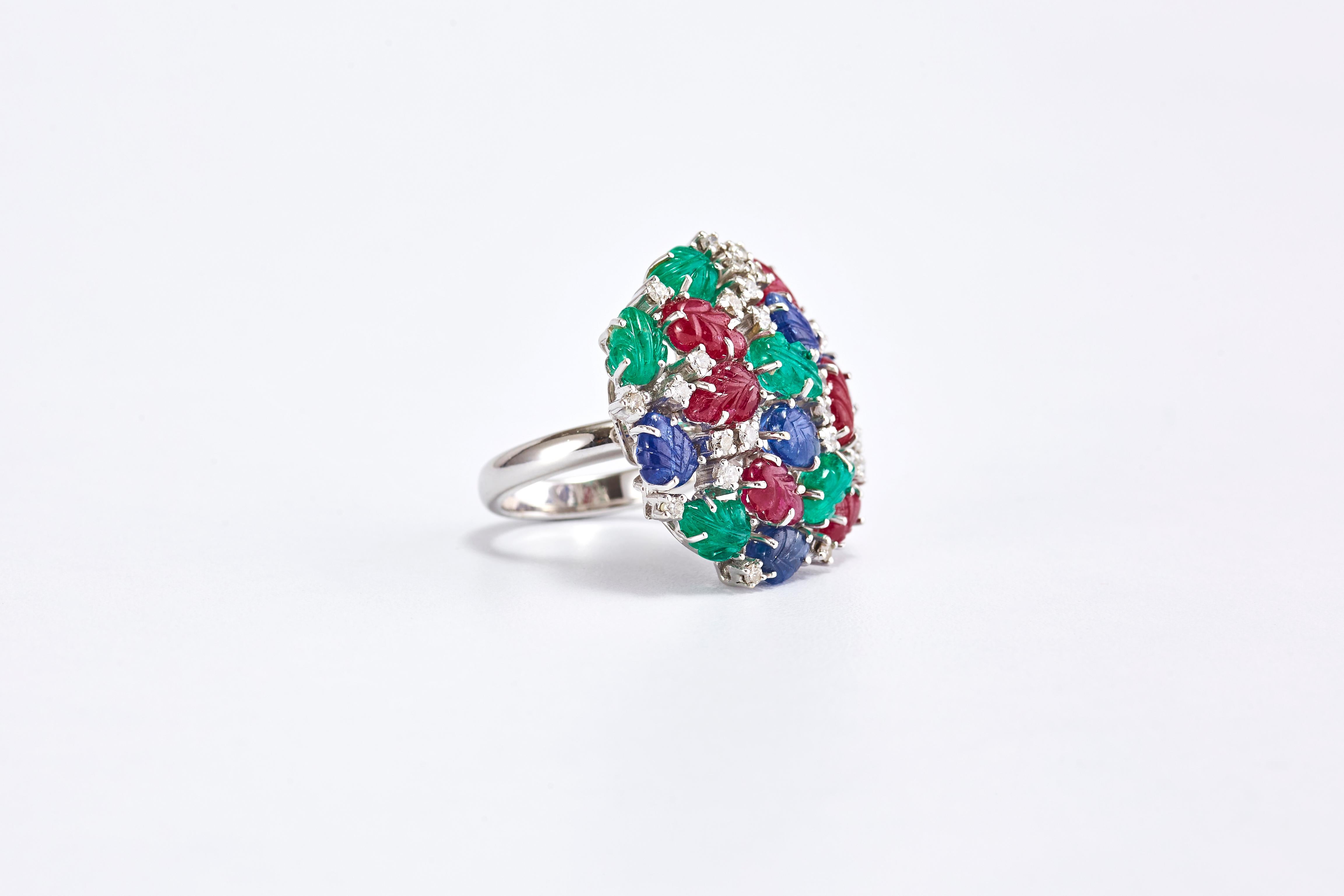 Anillo de Oro con Rubí, Zafiro, Esmeralda y Diamantes 

Un anillo especial de oro blanco con 3 tipos de gemas y diamantes que se extienden formando un gran círculo. Gemas en forma de hoja con grabado. Fabricado en Francia hacia el año