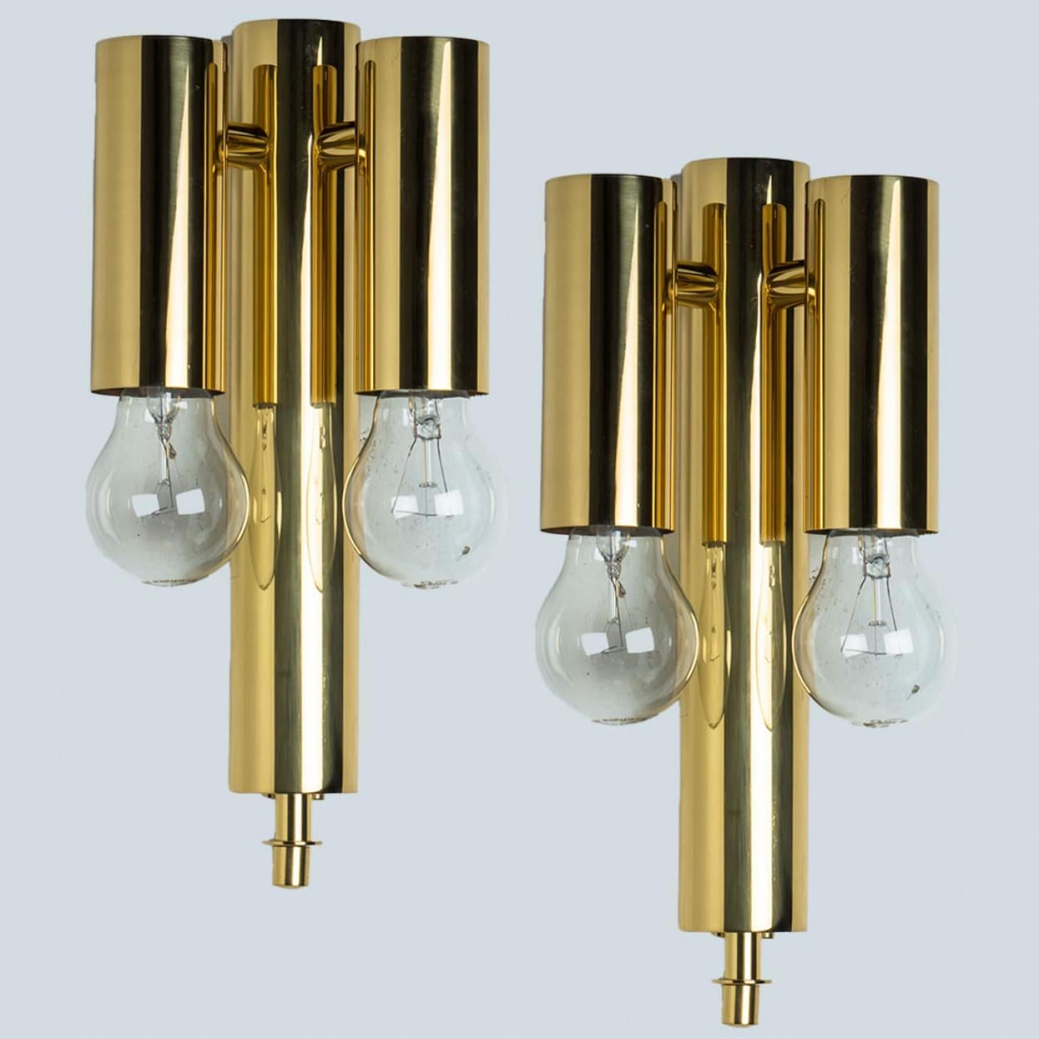 Wonderful high-end wall sconces in the style of Sciolari. With long hanging brass 'tubes' and brass details giving this piece an elegant appearance which refracts the light, filling a room with a soft, warm glow.
The wall sconce has a brass back