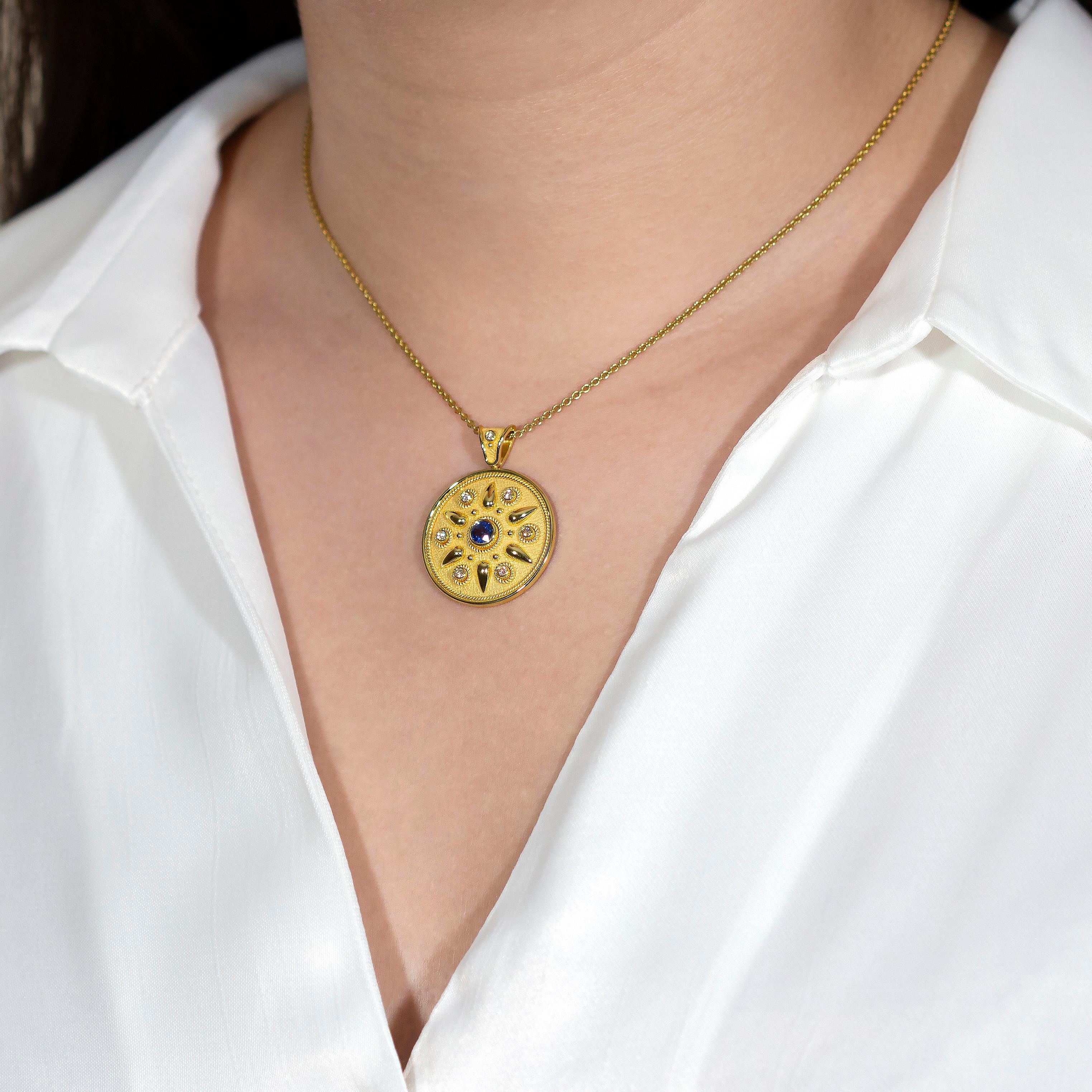 Elevate your style with this exquisite gold round pendant, adorned with a brilliant sapphire, glistening diamonds, and radiant gold accents. Experience the allure of timeless elegance, as this pendant beautifully combines luxurious gemstones with
