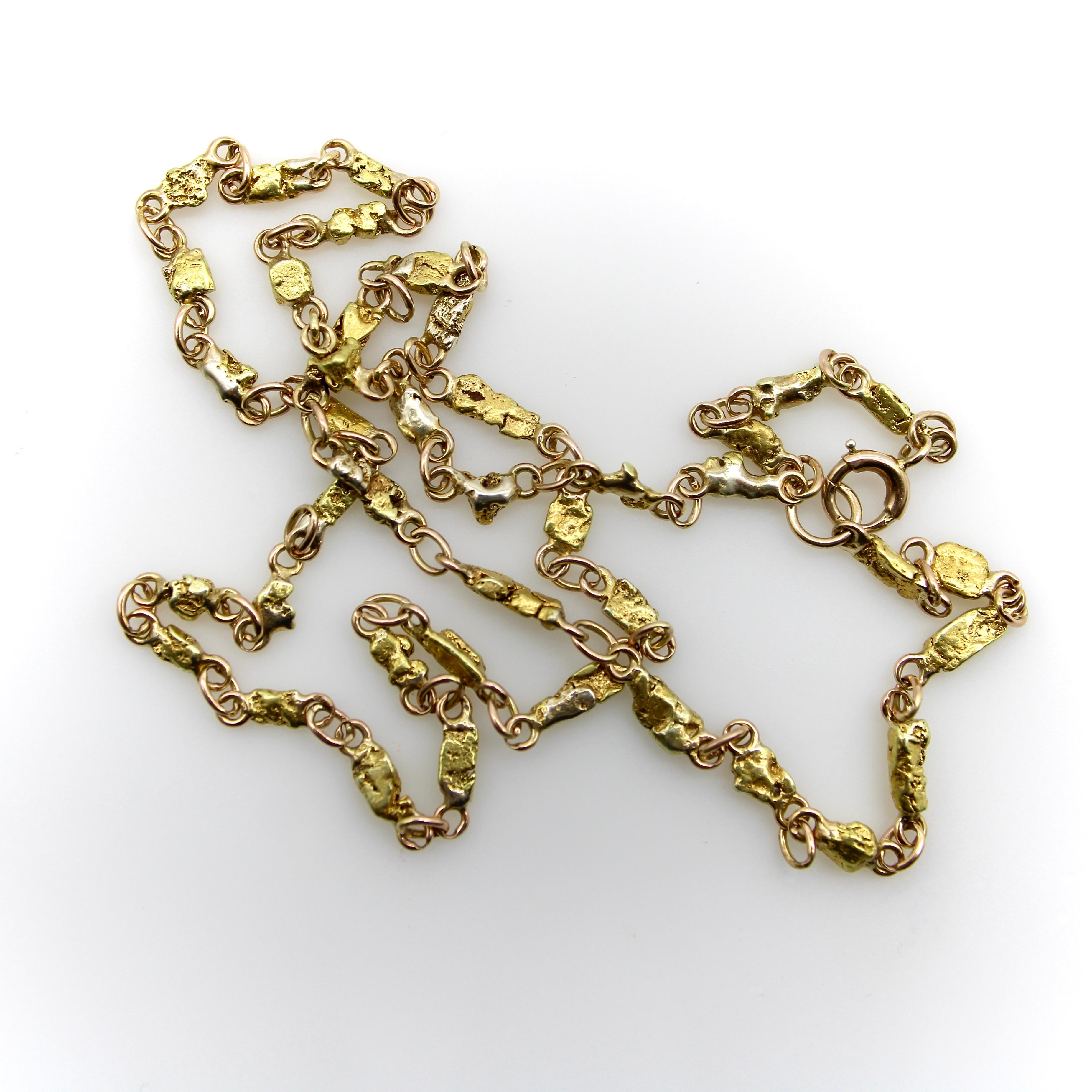 This is a delicately crafted gold nugget chain, most likely from the Alaskan Gold Rush era around 1910. The chain consists of small, well-matched gold nuggets with elegantly crafted jump rings on either side, held together by oval links. The chain