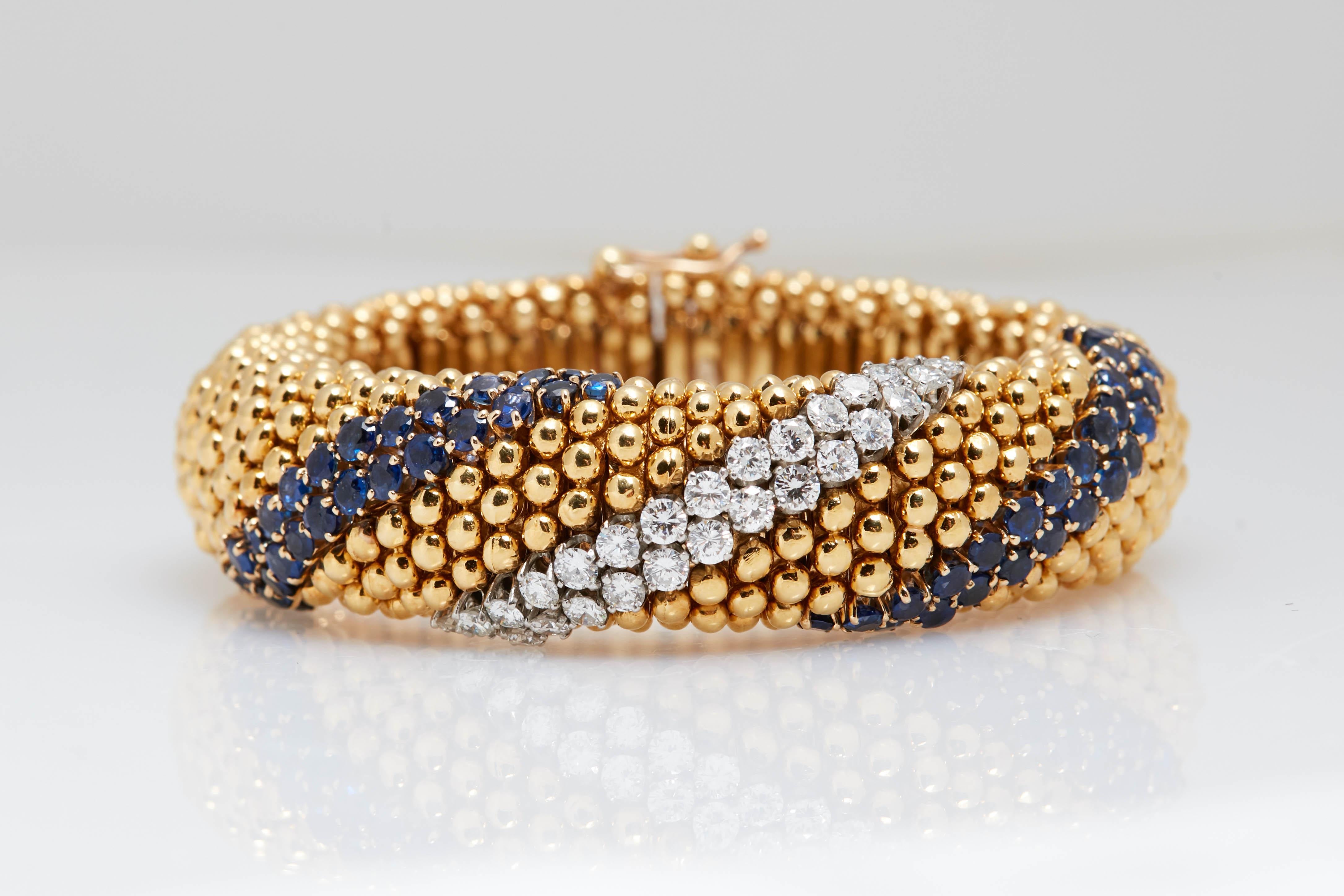 18kt Yellow Gold, Sapphire and Diamond Cous-Cous Bracelet.; the articulated links topped by bombé clusters of polished gold balls, centering a diagonal section of 28 round diamonds approximately 1.95 cts., flanked by diagonal bands of 56 round
