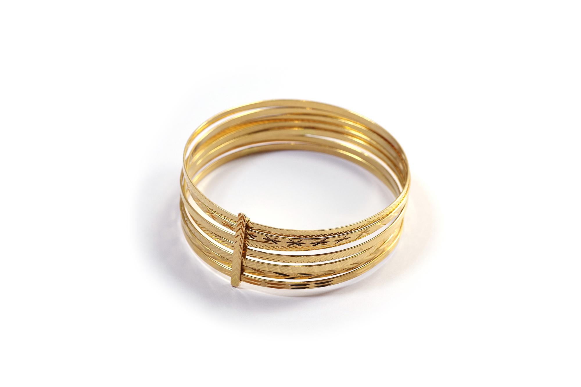 Gold semainier bracelet in yellow gold 18 karats. The bracelet is composed of seven large rings symbolizing the days of the week, united by a bar. The rings are engraved with geometric patterns. Vintage bracelet, circa 1990, France.

Eagle's head